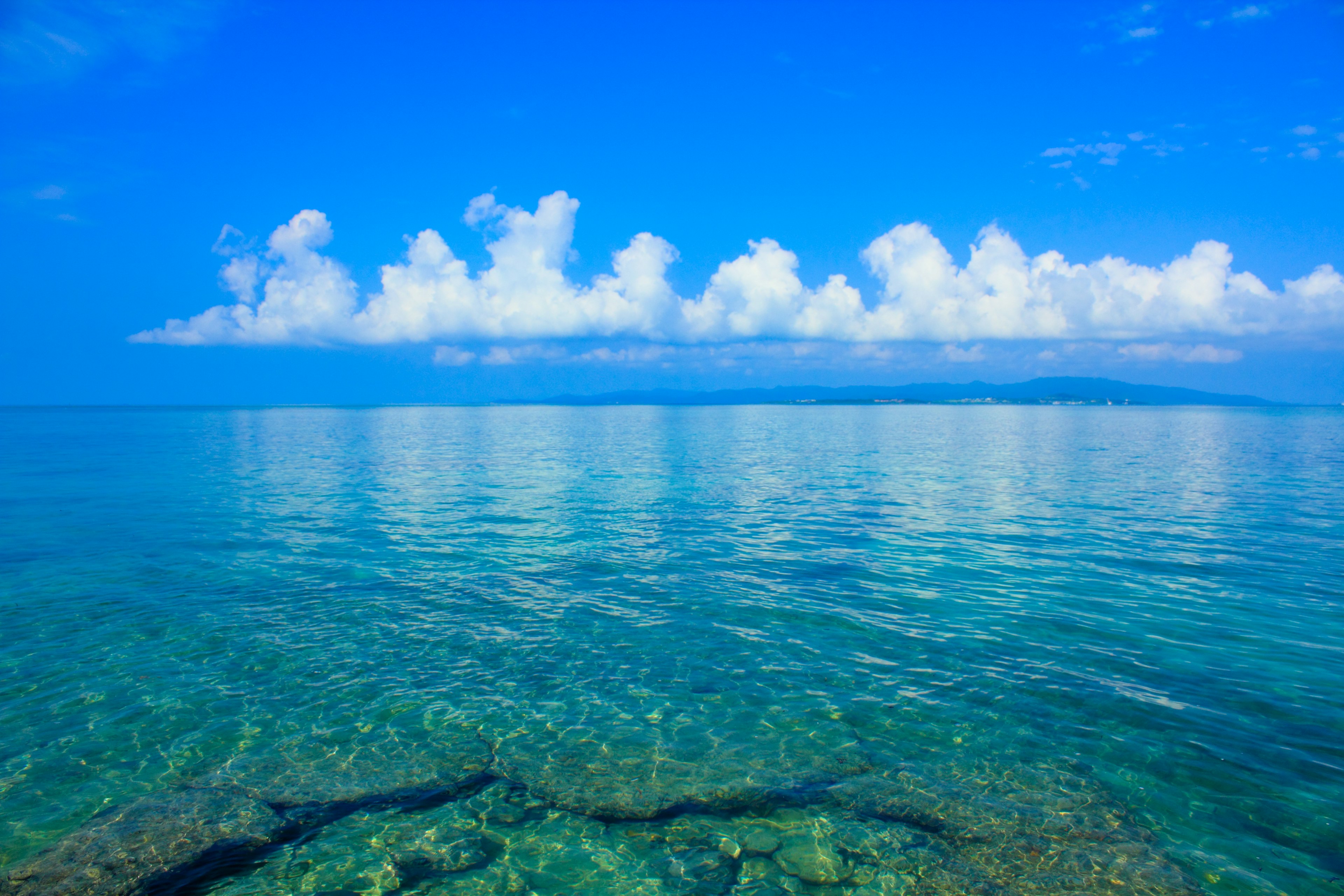 Klares blaues Meer mit weißen Wolken am Himmel