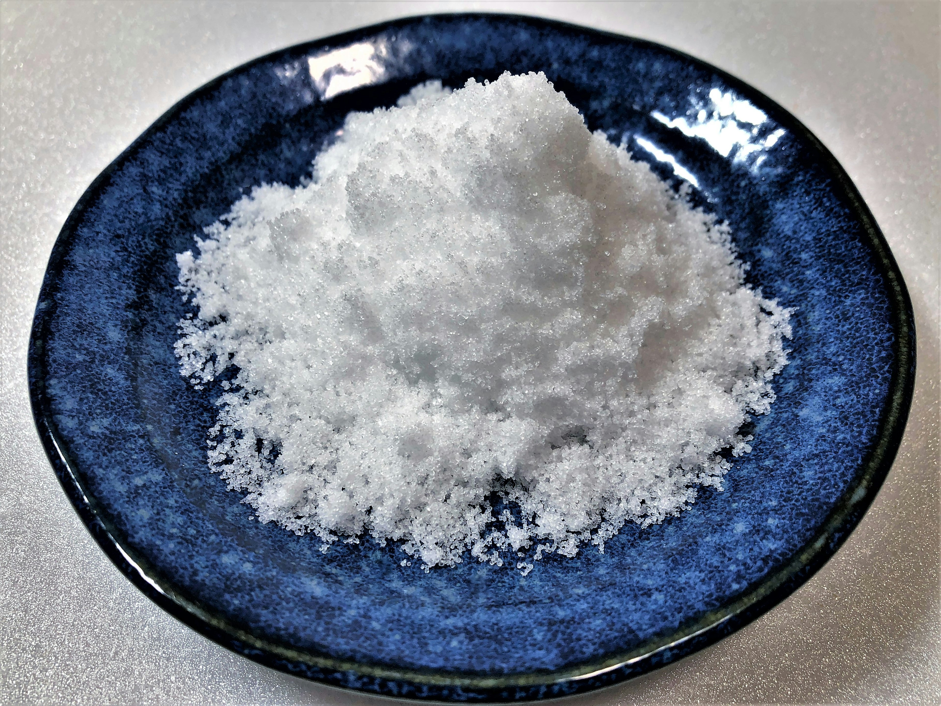 A mound of white salt on a blue plate