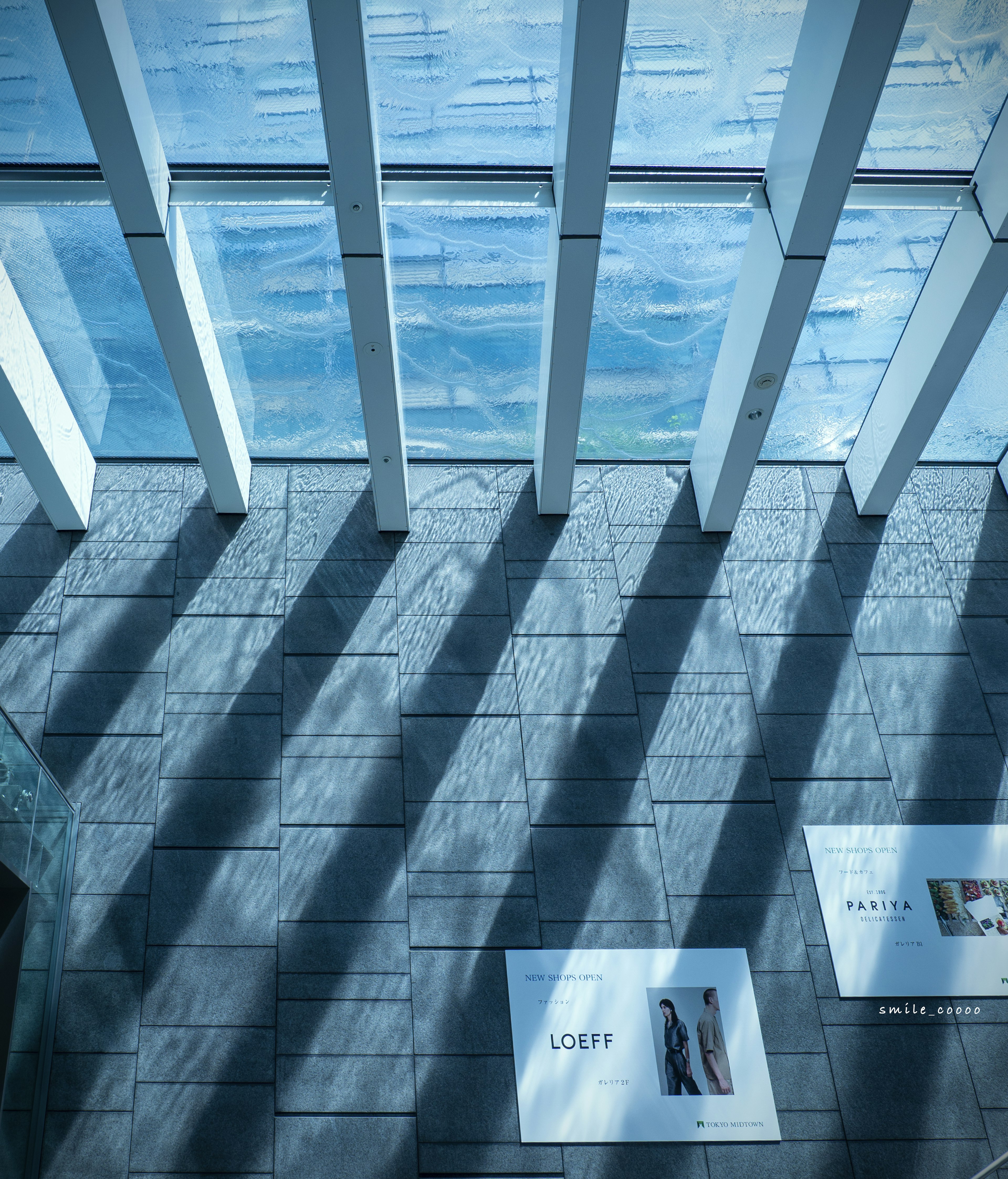 Interior of a modern building with blue water reflections and shadows