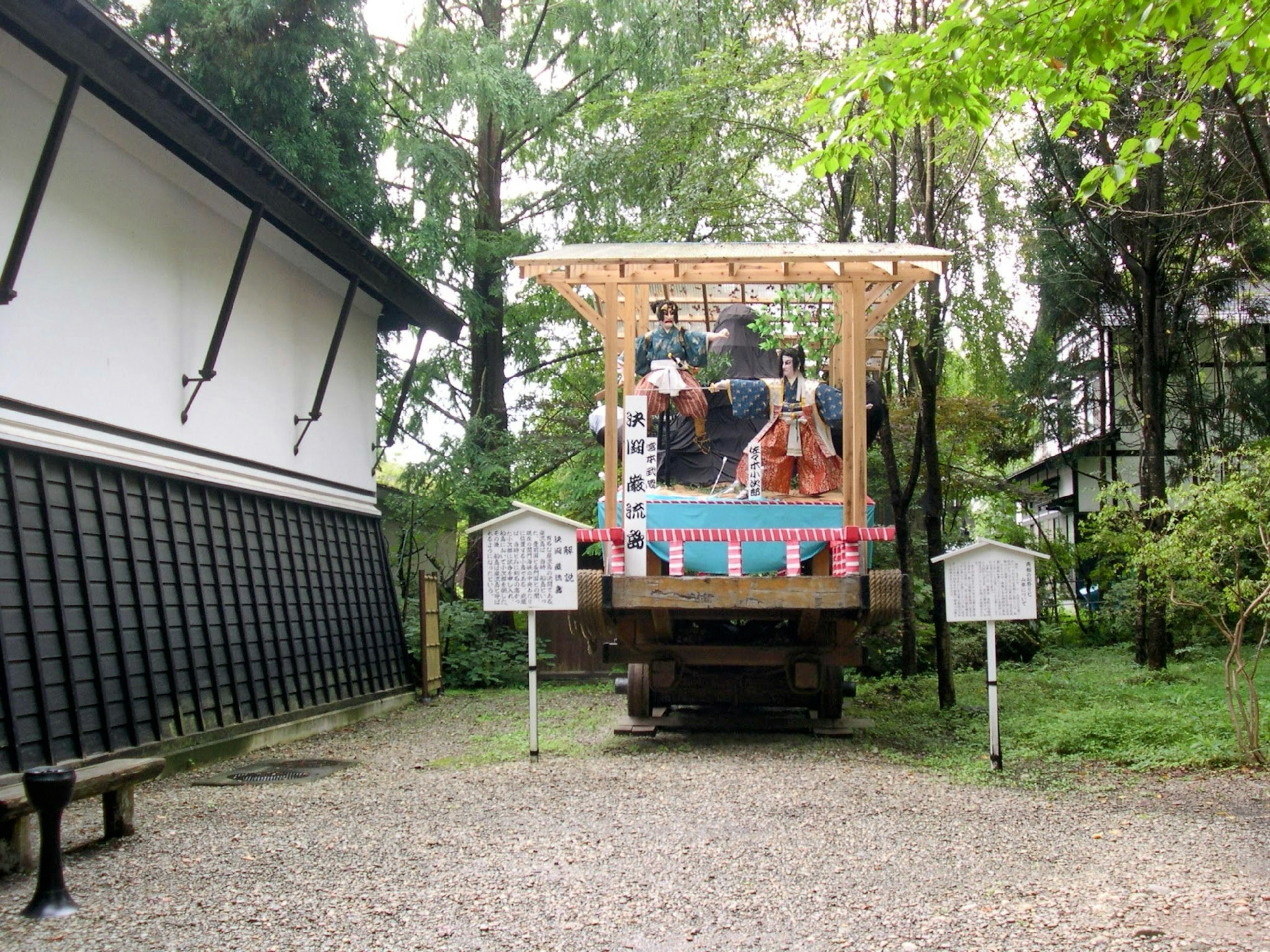 Traditional festival float in a forested area surrounded by greenery