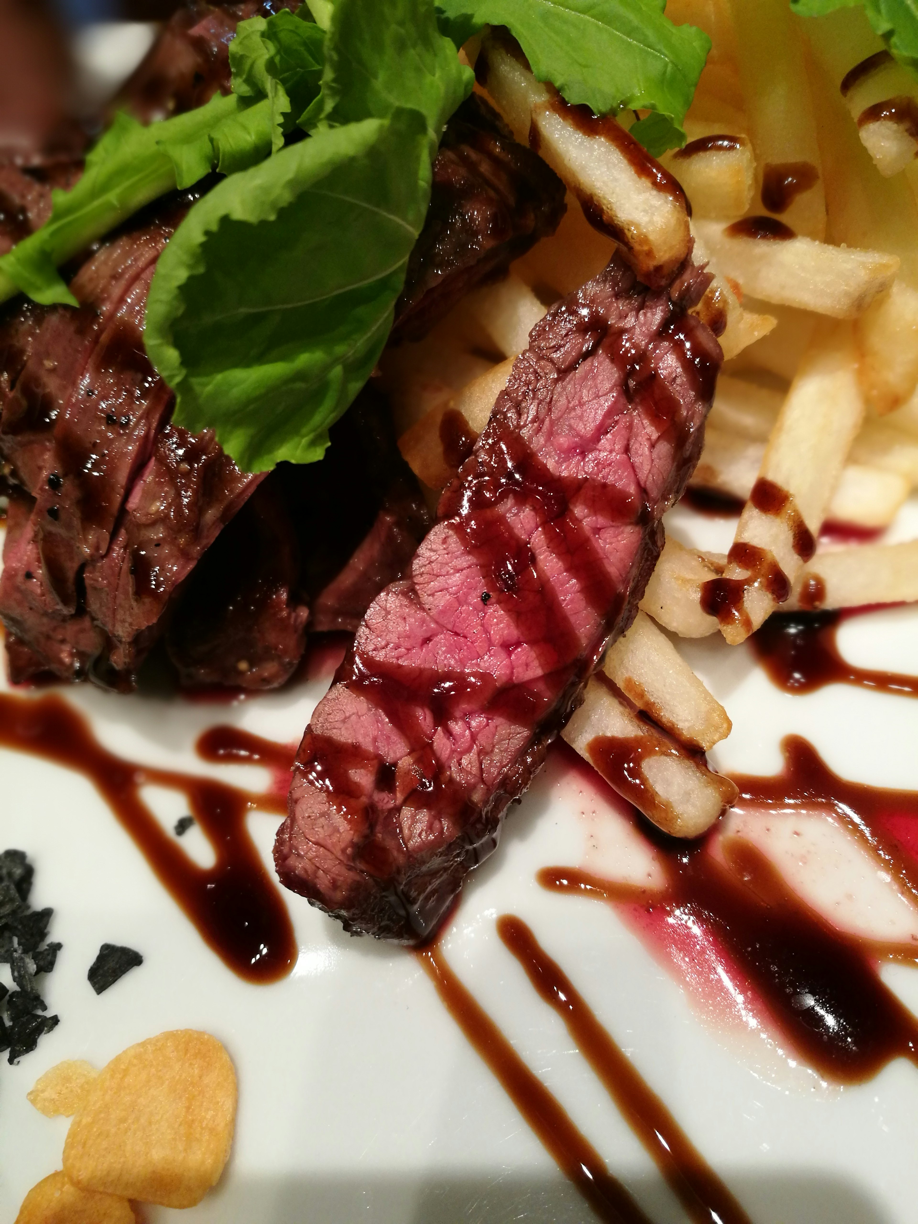 Saftiges Steak mit Pommes frites garniert mit Kräutern und Saucen