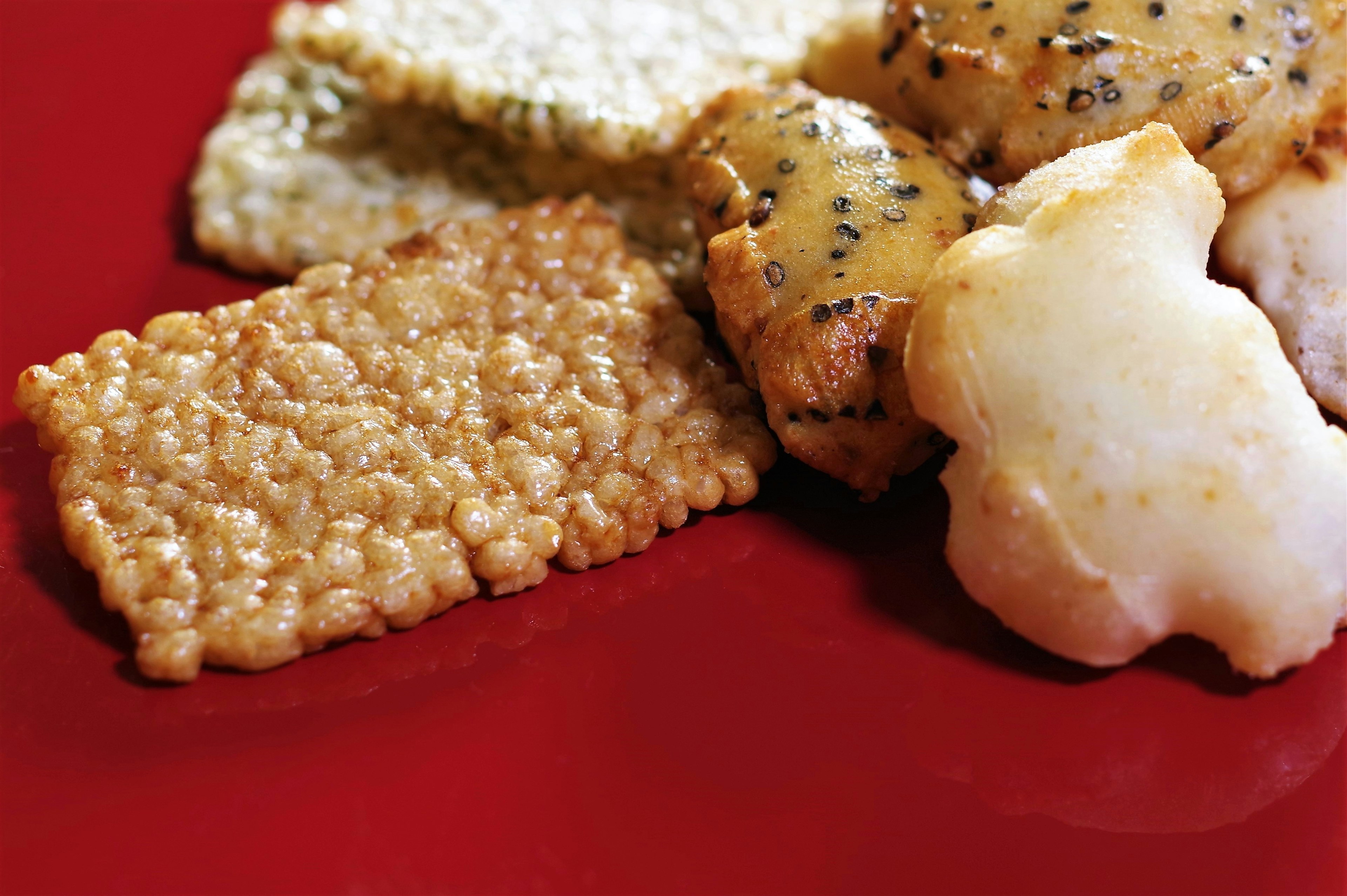 Various types of crackers and snacks arranged on a red plate