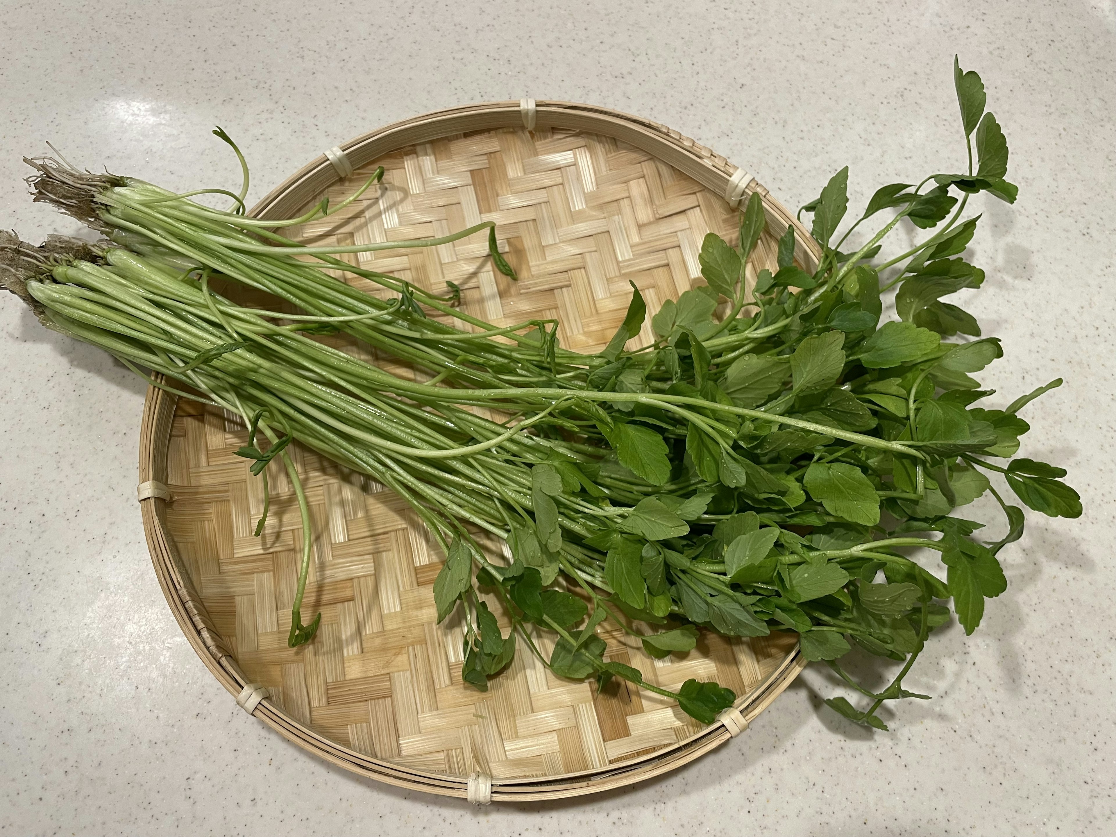 Herbes fraîches disposées sur une assiette en bambou