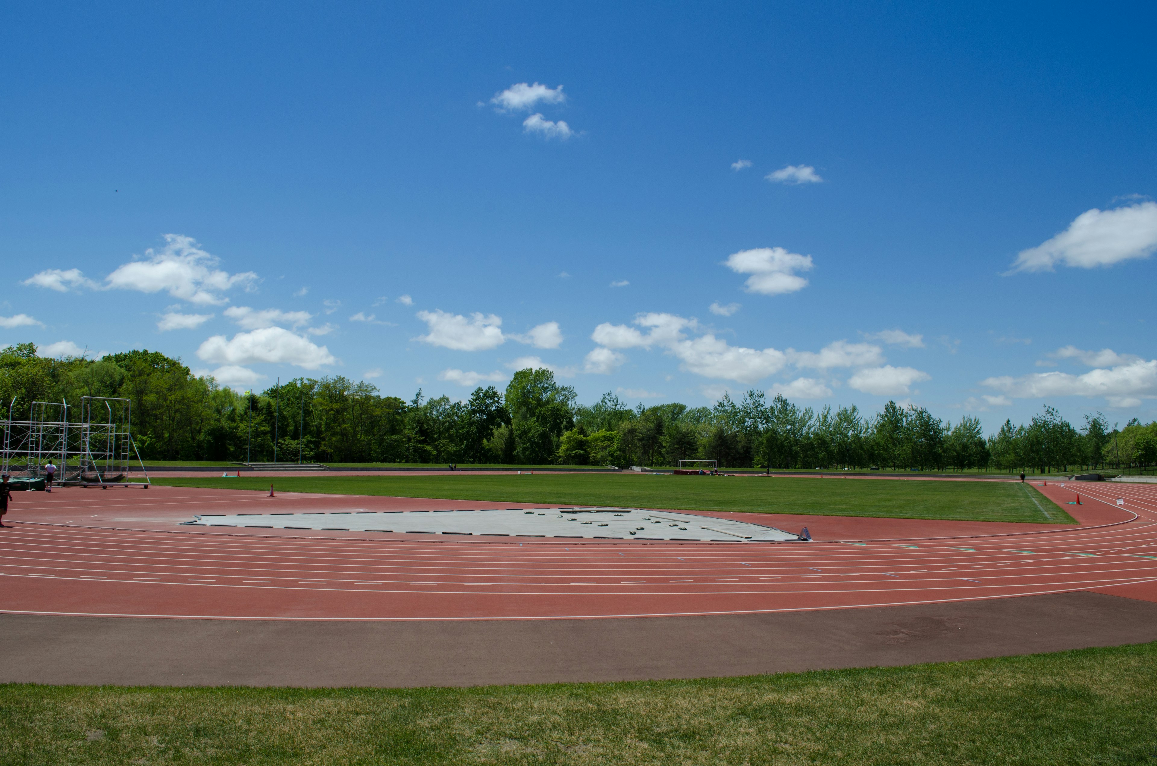 Leichtathletikbahn unter blauem Himmel mit grünem Gras