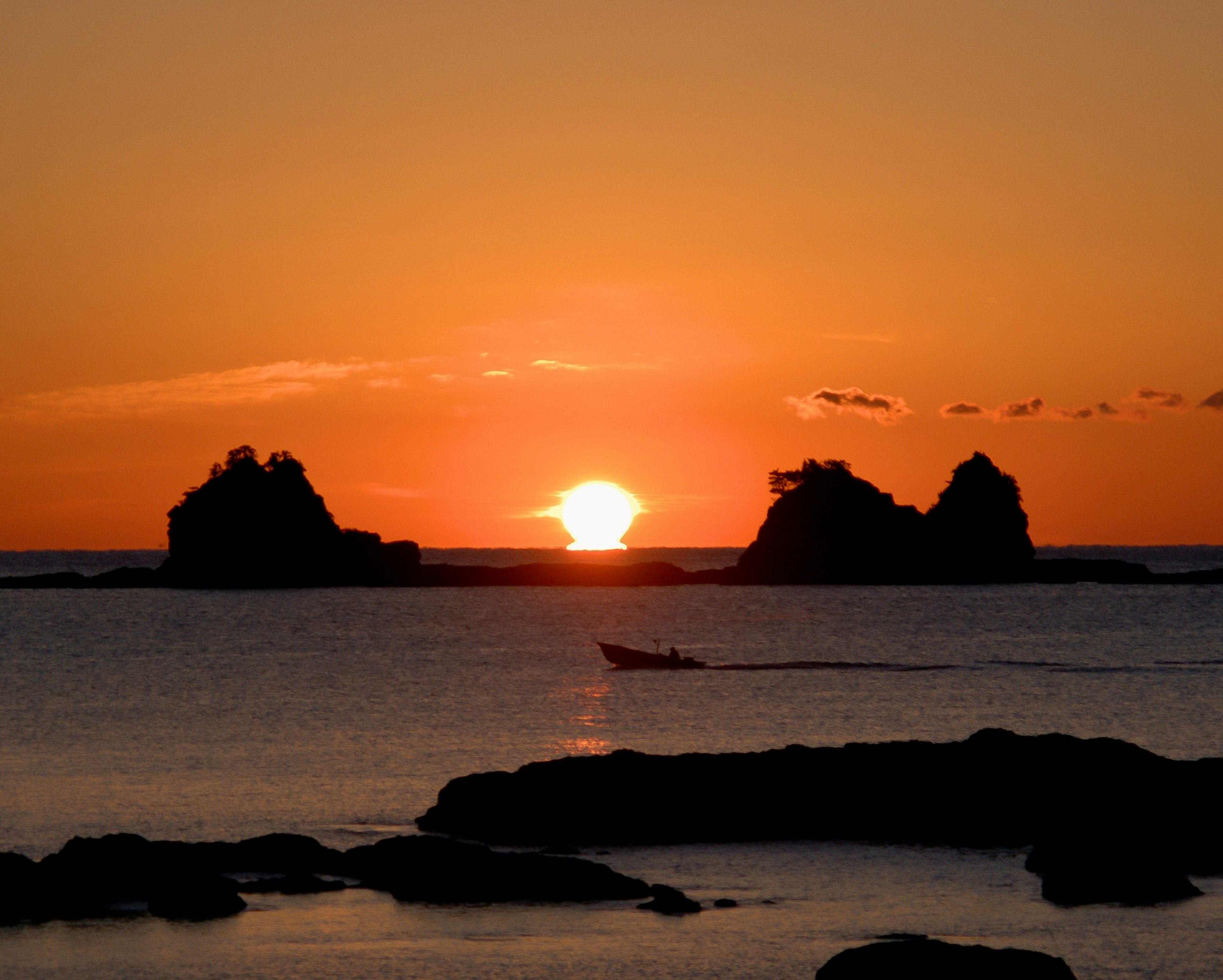 夕日が海に沈む美しい風景 岩のシルエットが際立つ