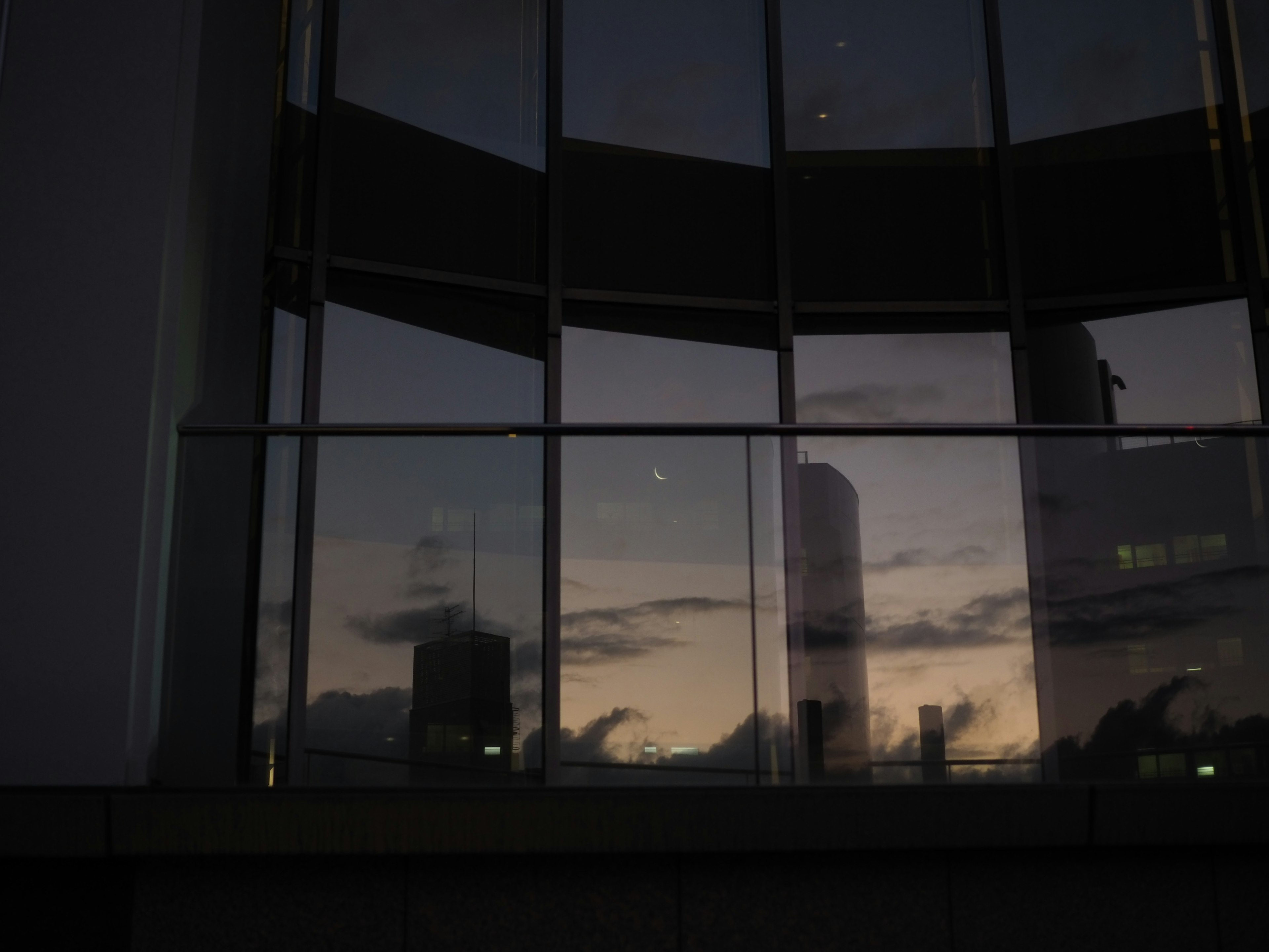 Reflet du ciel crépusculaire dans une fenêtre de bâtiment