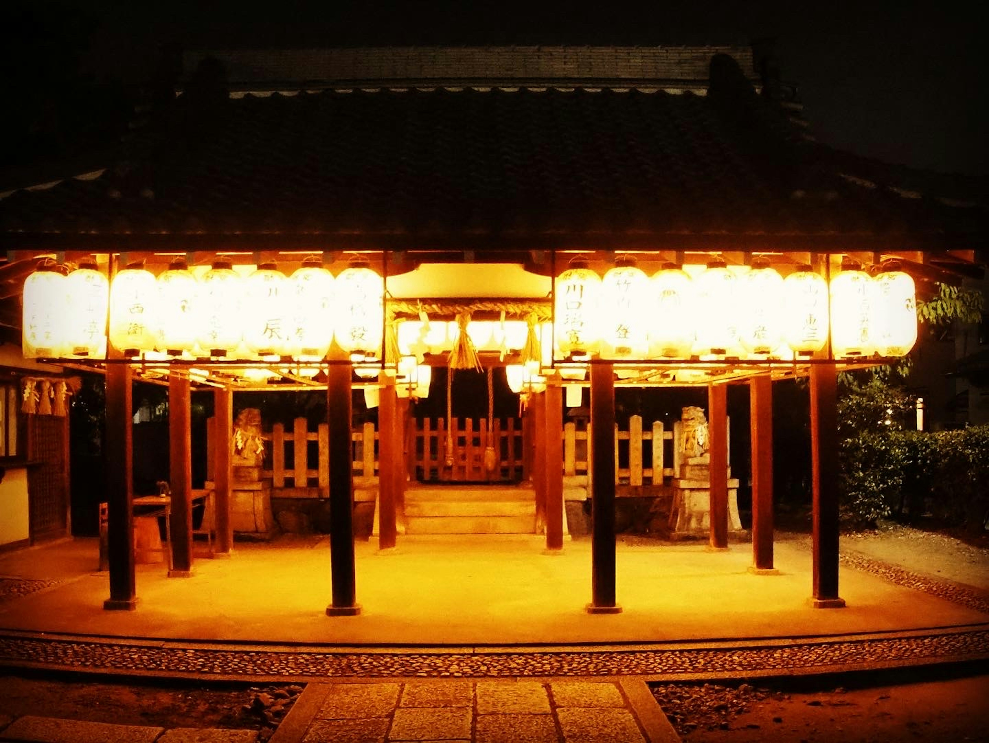 Traditional Japanese building illuminated by lanterns at night