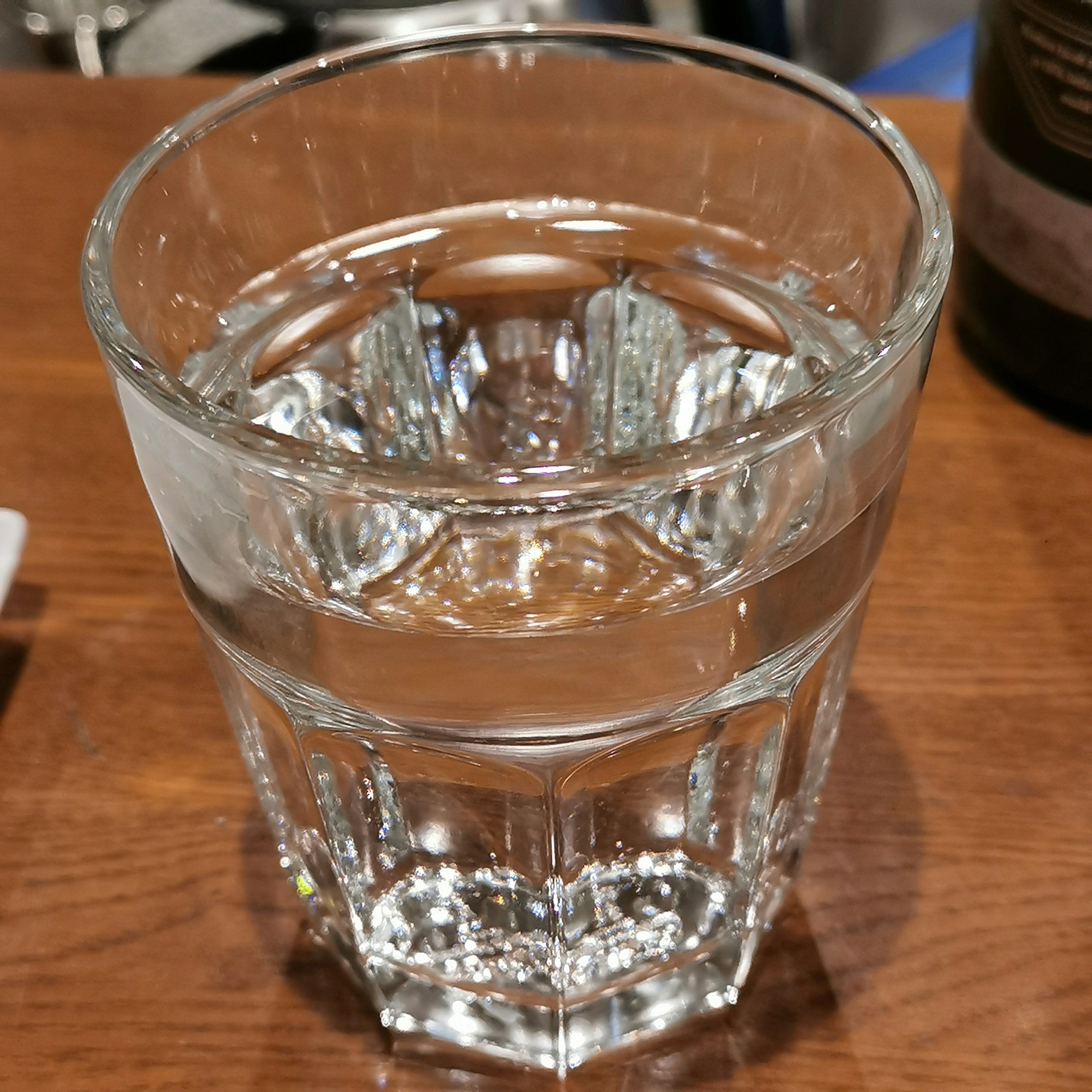 A glass of clear water placed on a wooden table