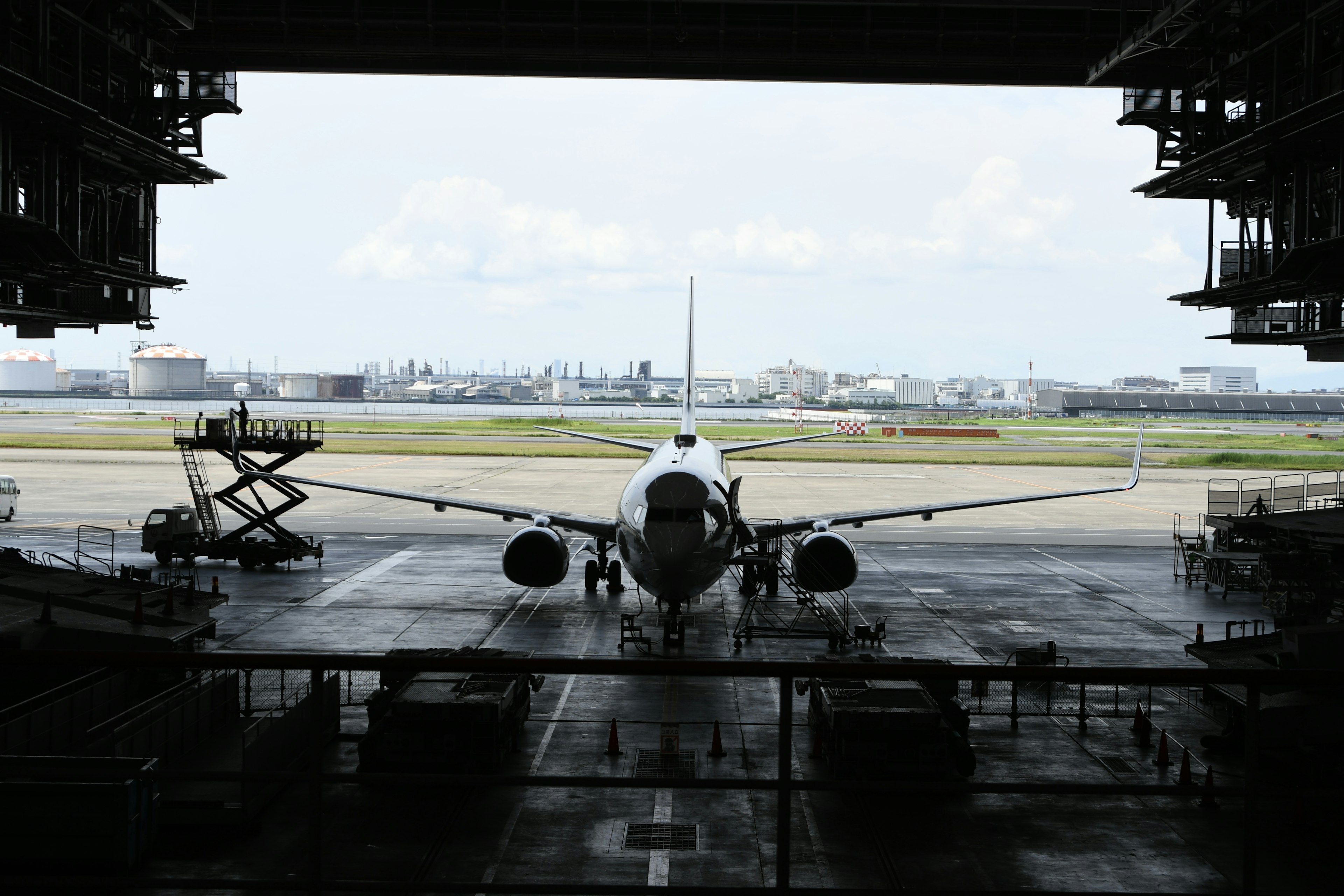 Airplane seen from hangar with runway in the background