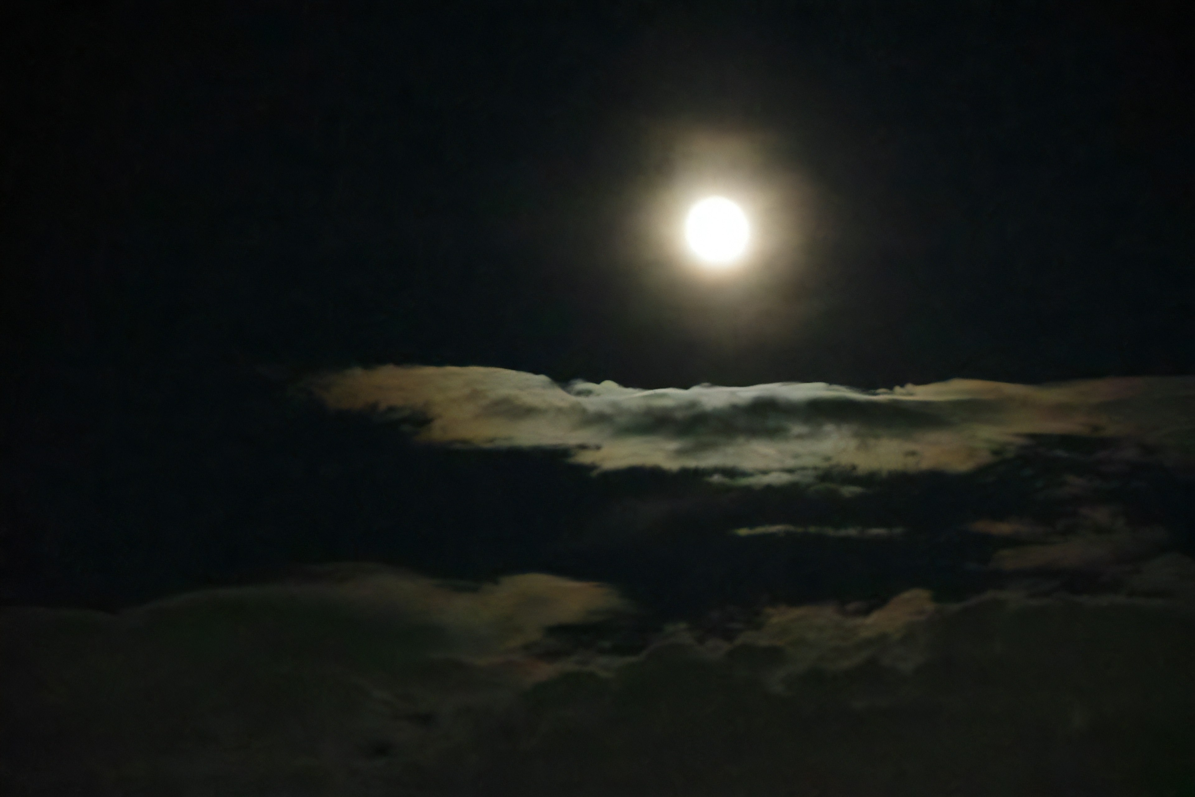 Lune pleine brillante dans le ciel nocturne avec des nuages