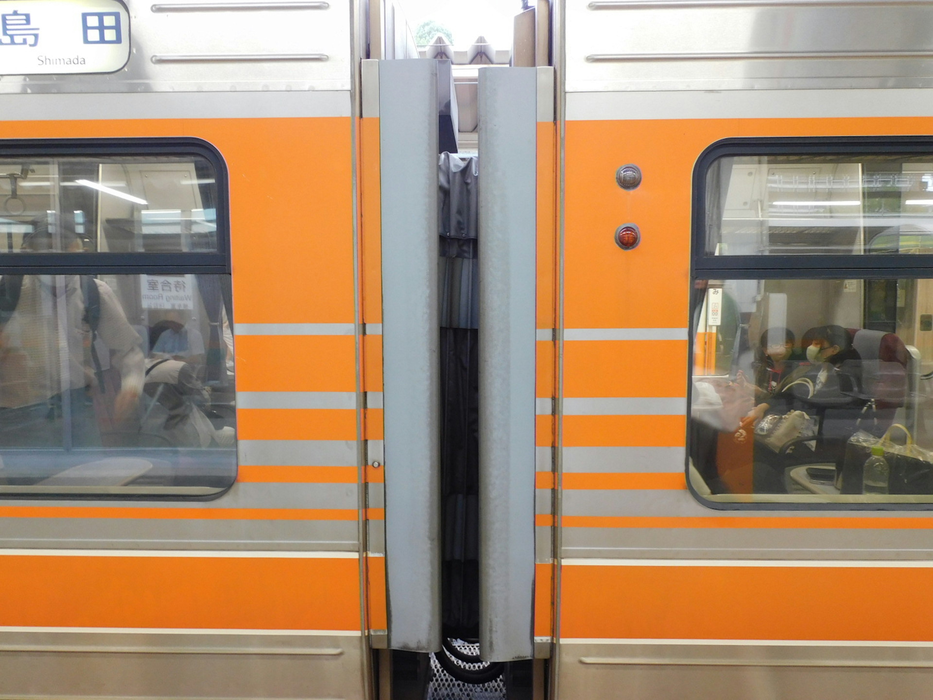 Portes et fenêtres de voiture de train orange visibles entre les wagons