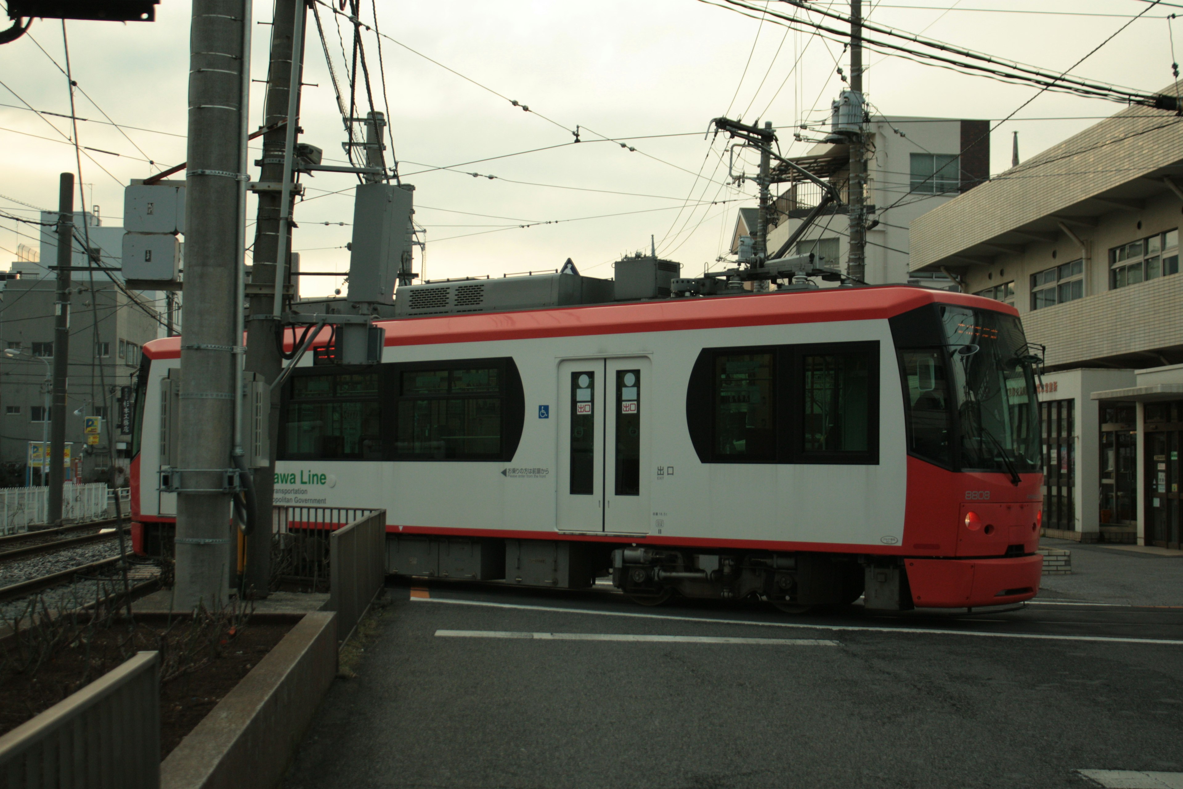 Tram rouge et blanc tournant à un carrefour