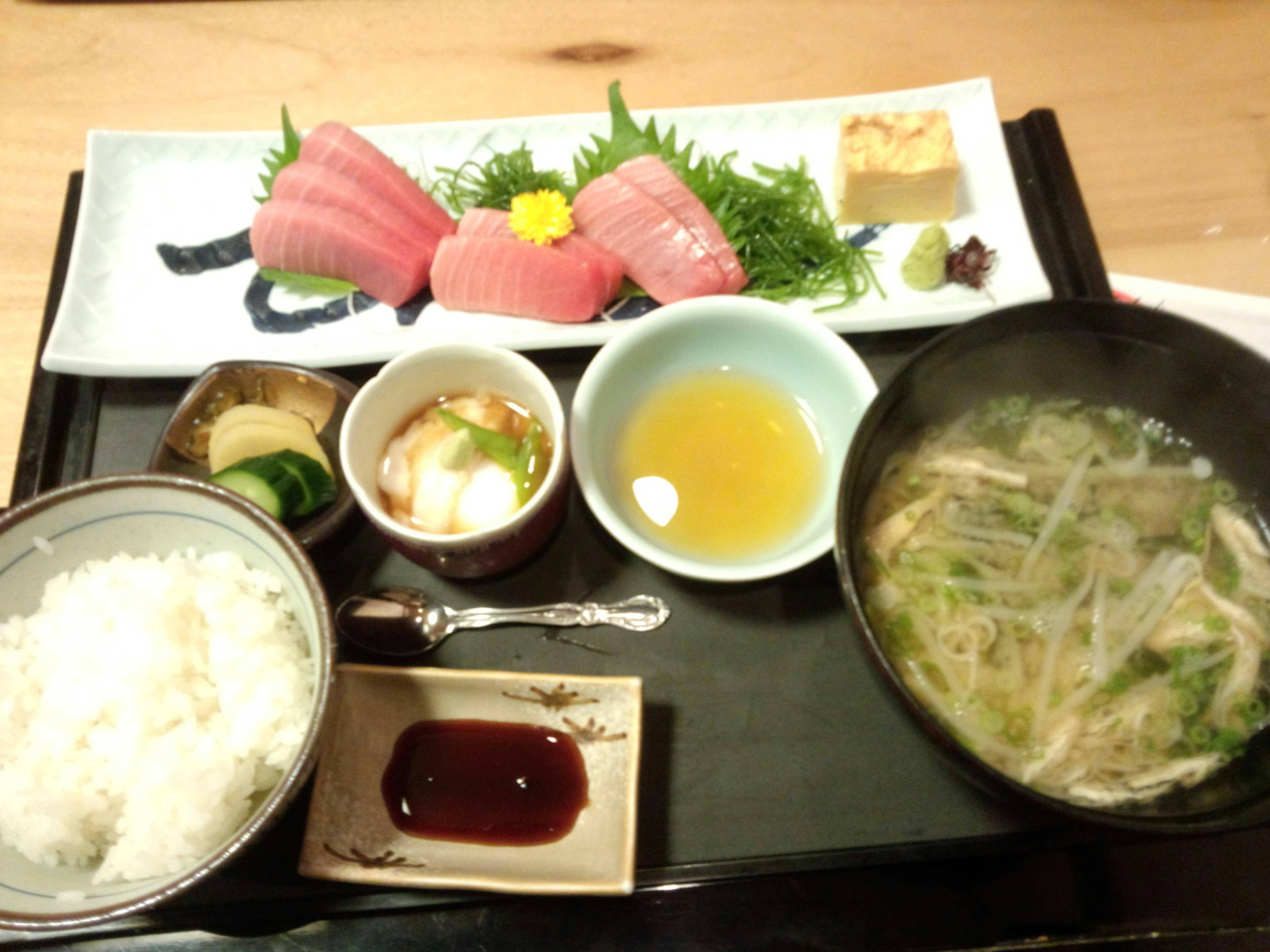 Japanese meal featuring fresh sashimi rice soup and dessert