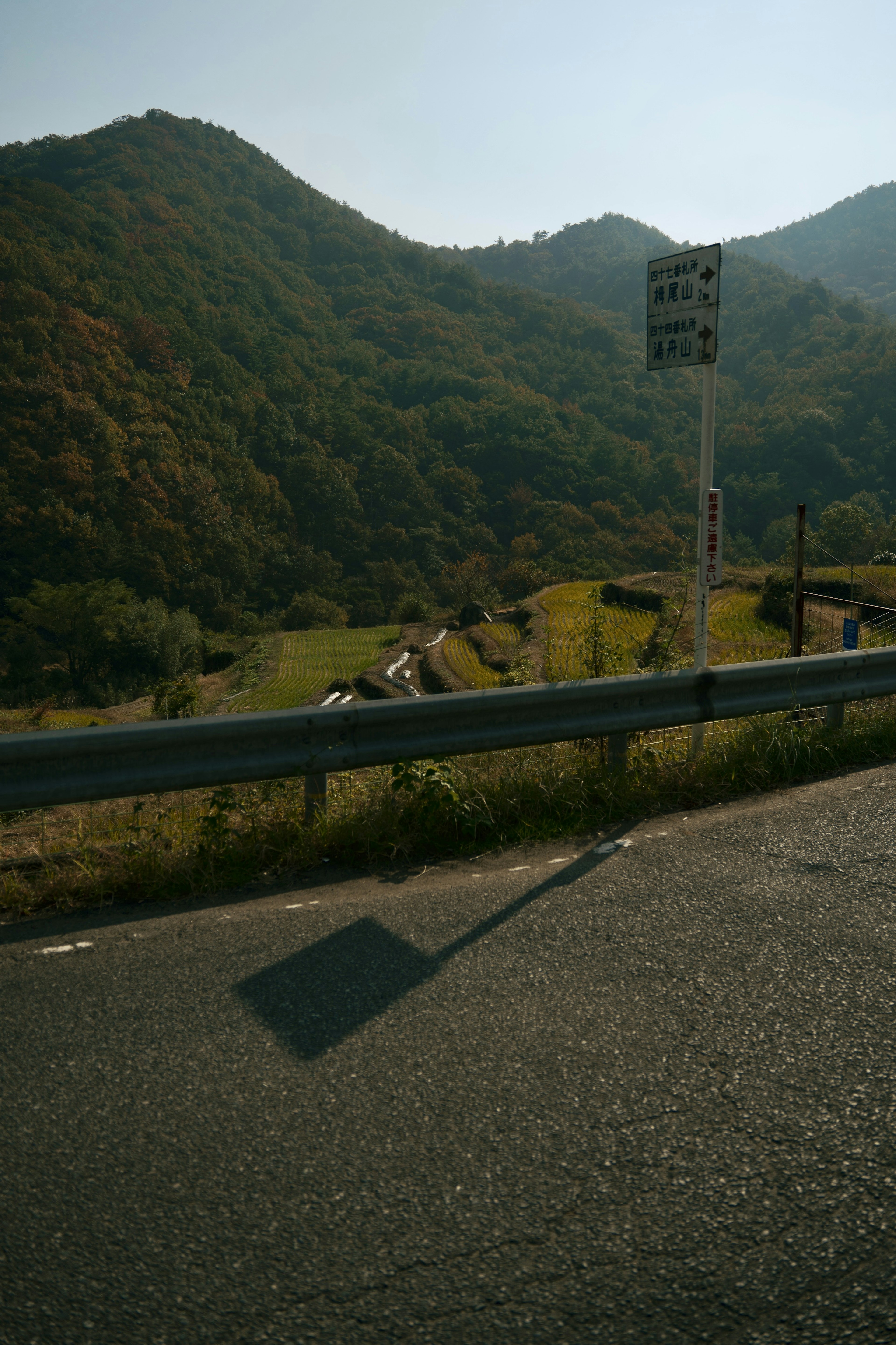 山々に囲まれた道路の風景で交通標識が見える