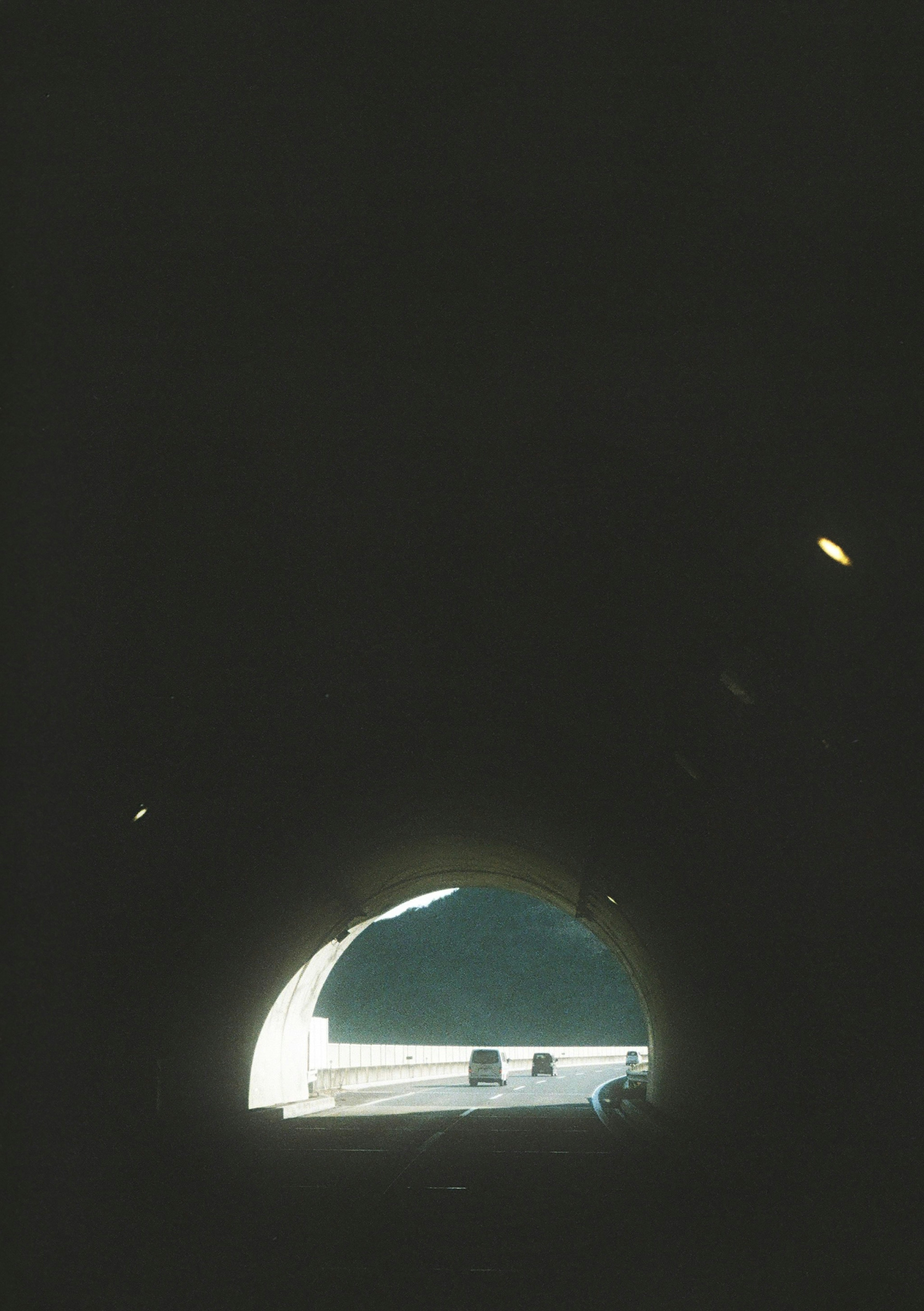 View from inside a tunnel showing a bright exit and dark surroundings