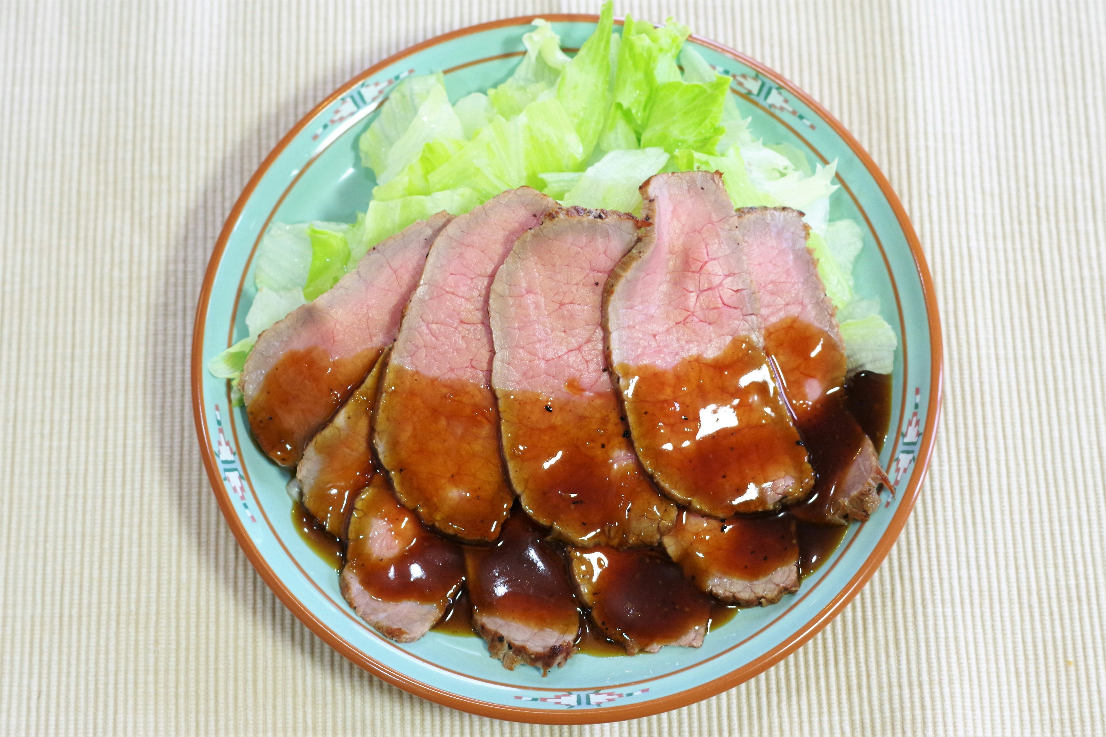 In Scheiben geschnittenes Rinderbraten mit Salat auf einem Teller