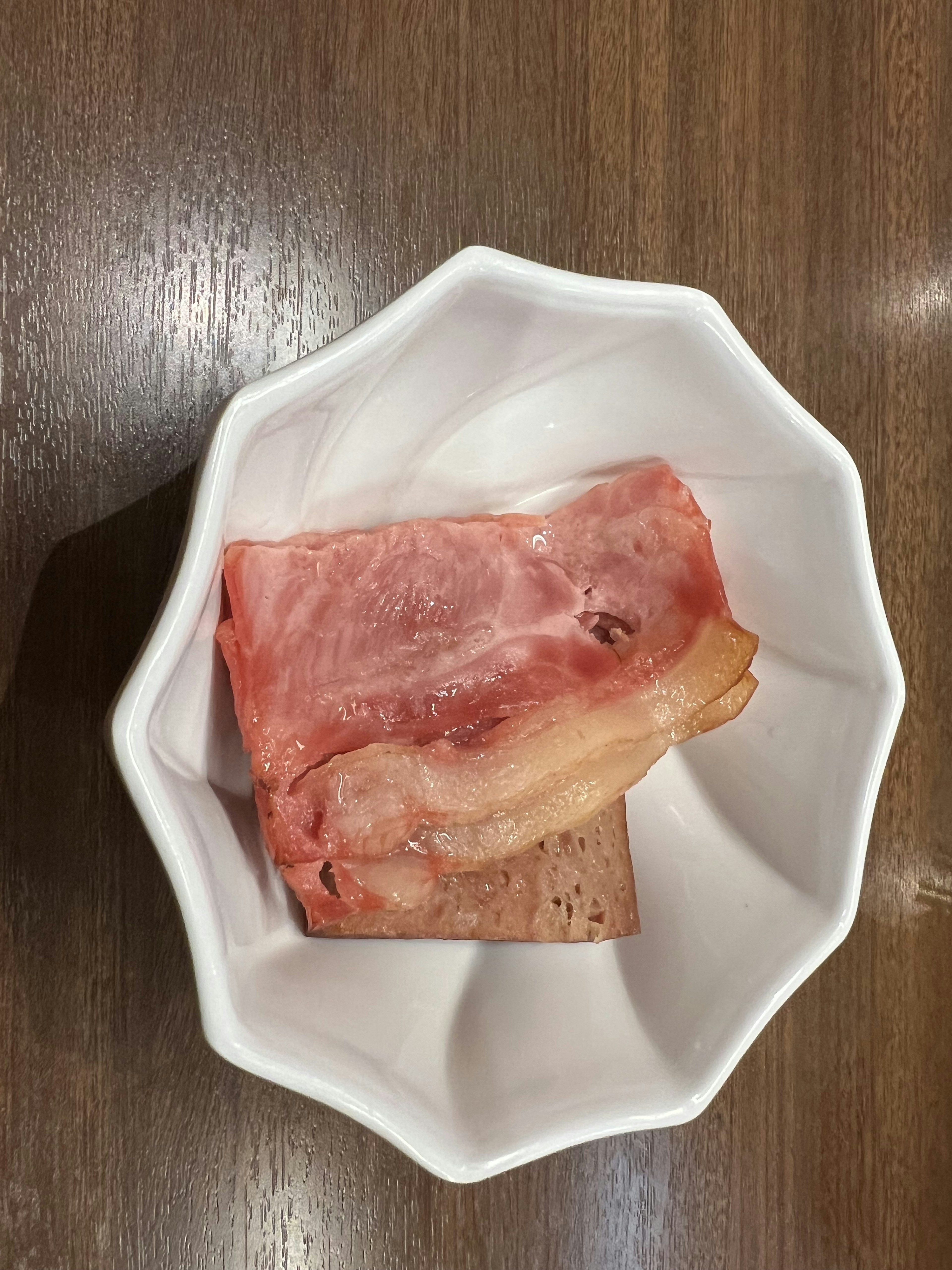 Tranches de viande et de graisse présentées dans un plat blanc