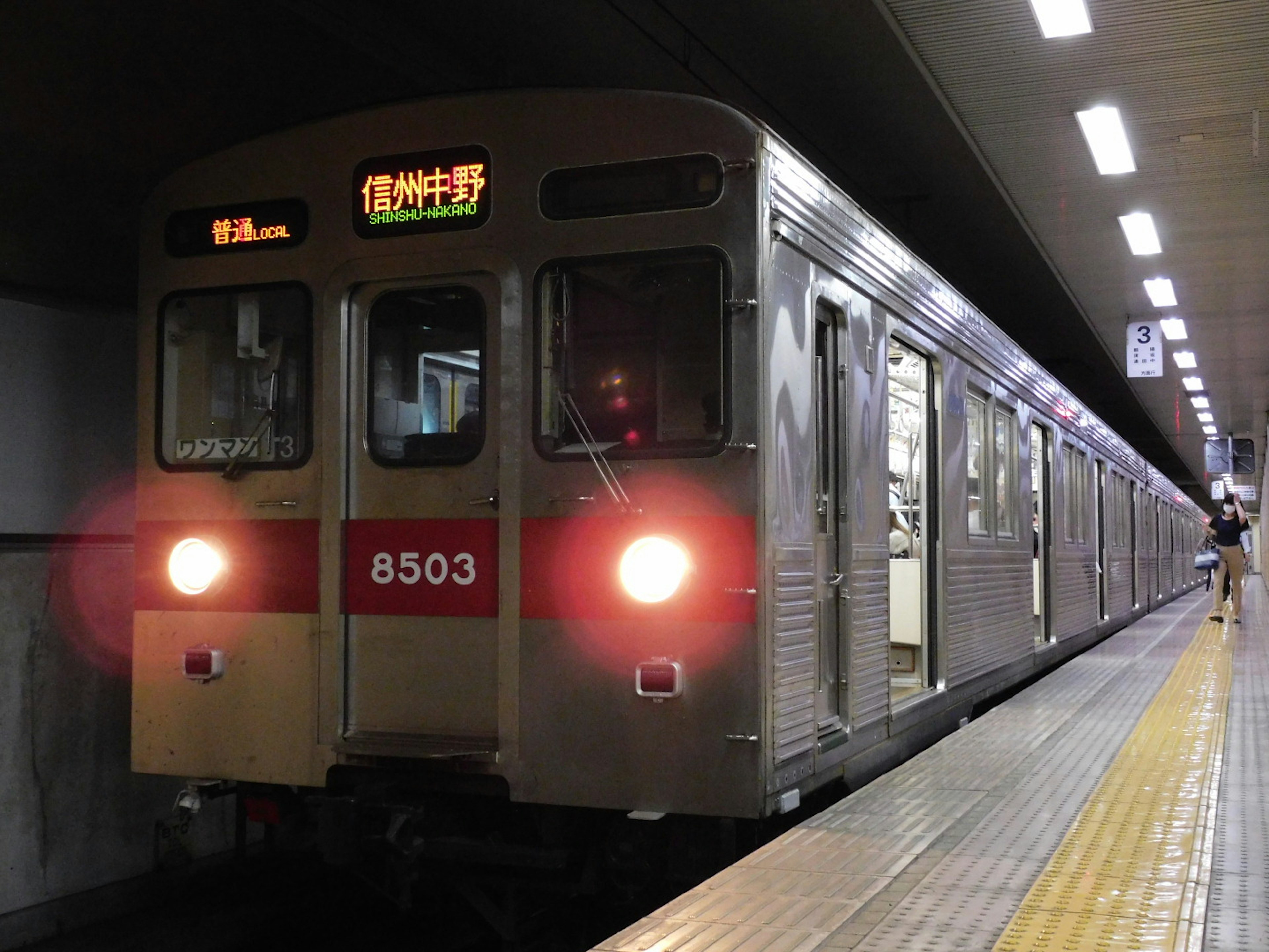 Tren de metro detenido en una estación con letrero de destino iluminado