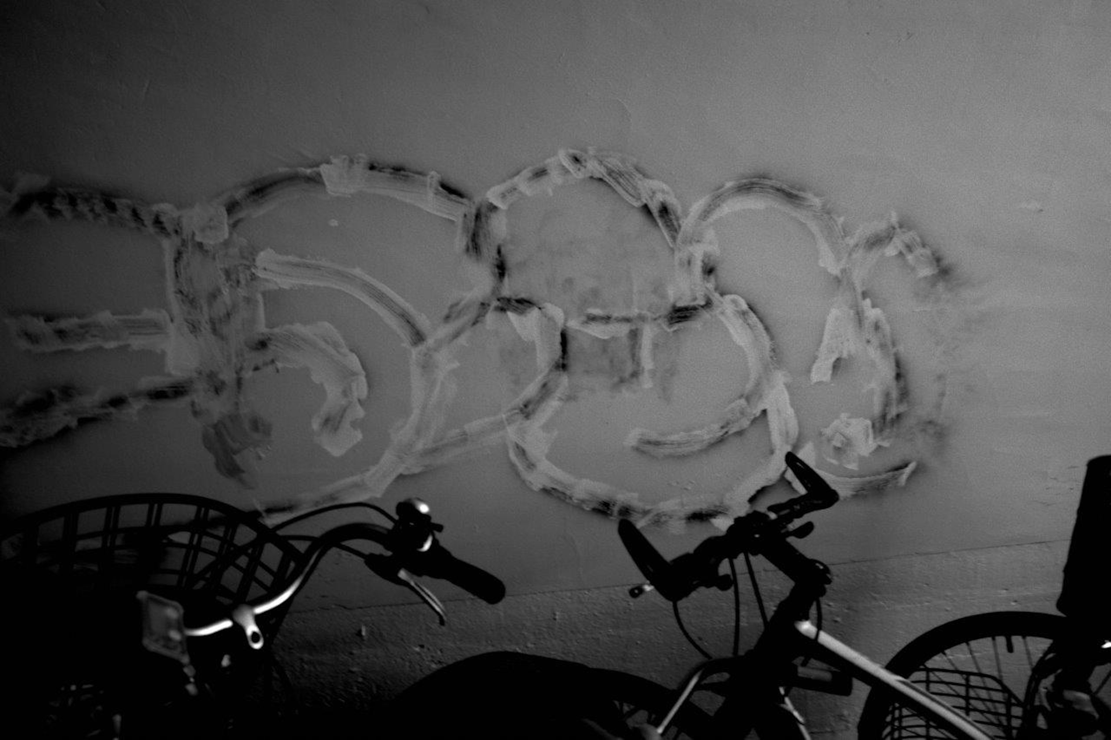 Bicycles beside an abstract pattern on the wall