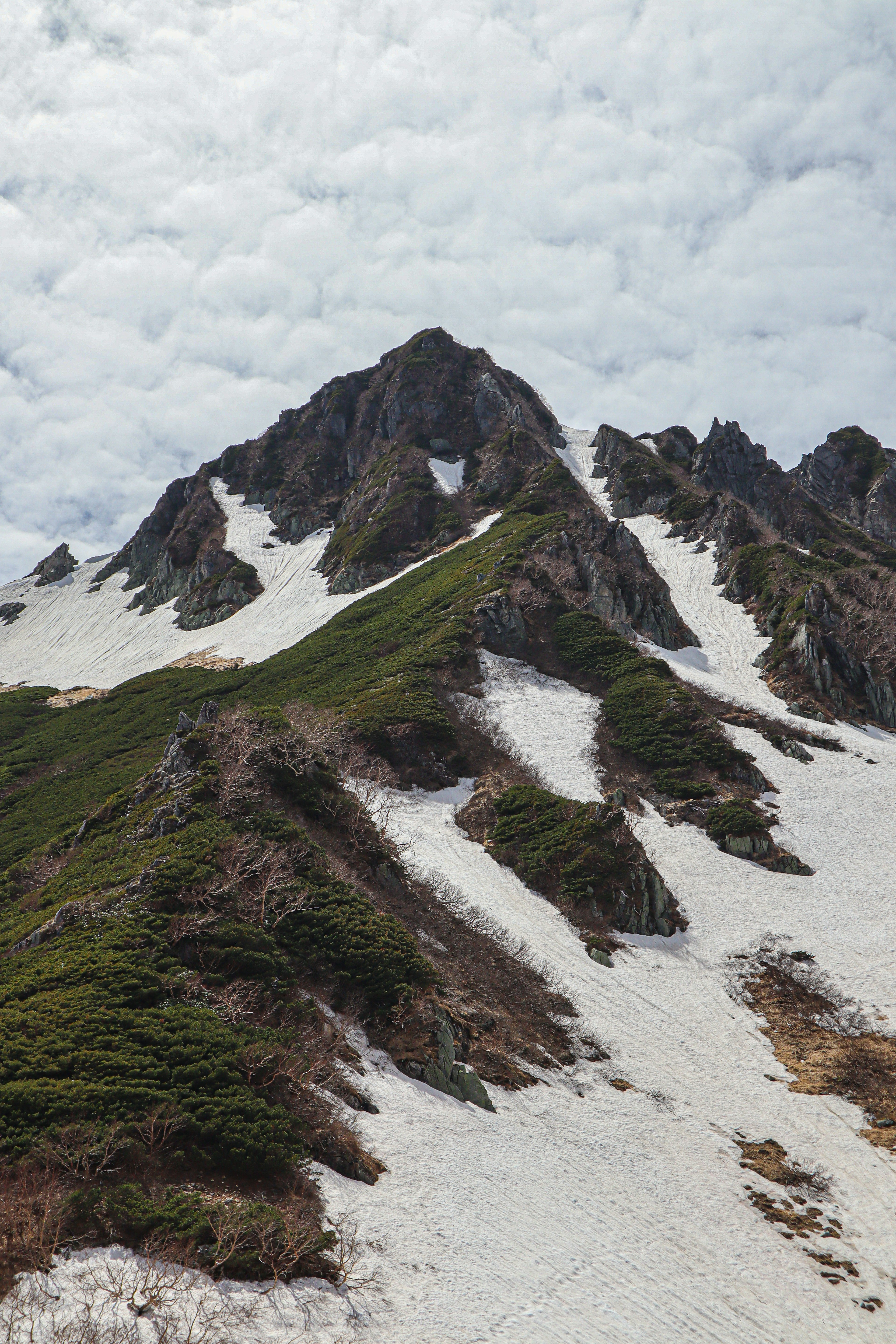 Snow-covered mountain slopes with a cloudy sky