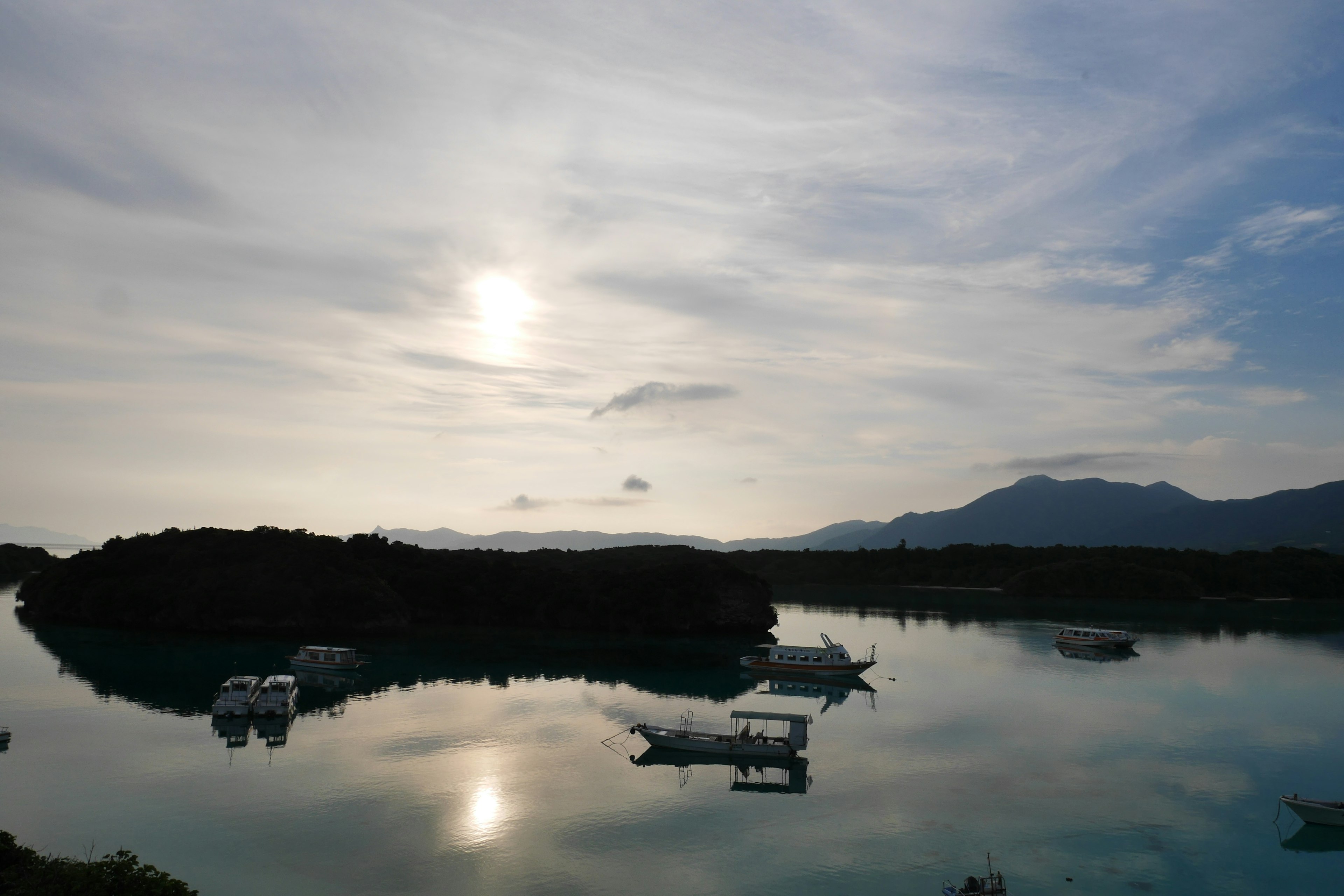 Lac tranquille reflétant le coucher de soleil et des bateaux