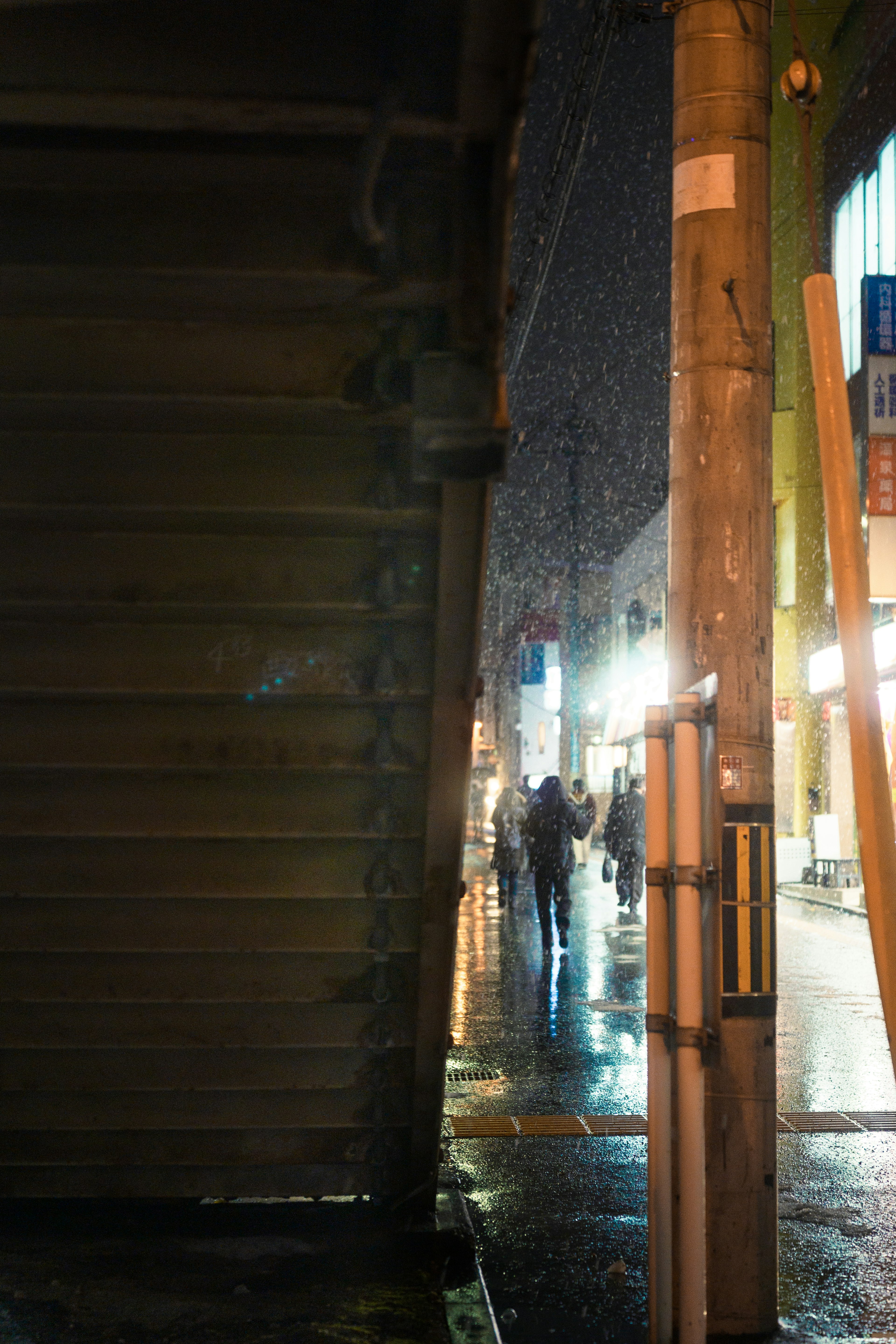 Des gens marchant dans la neige la nuit avec des lampadaires