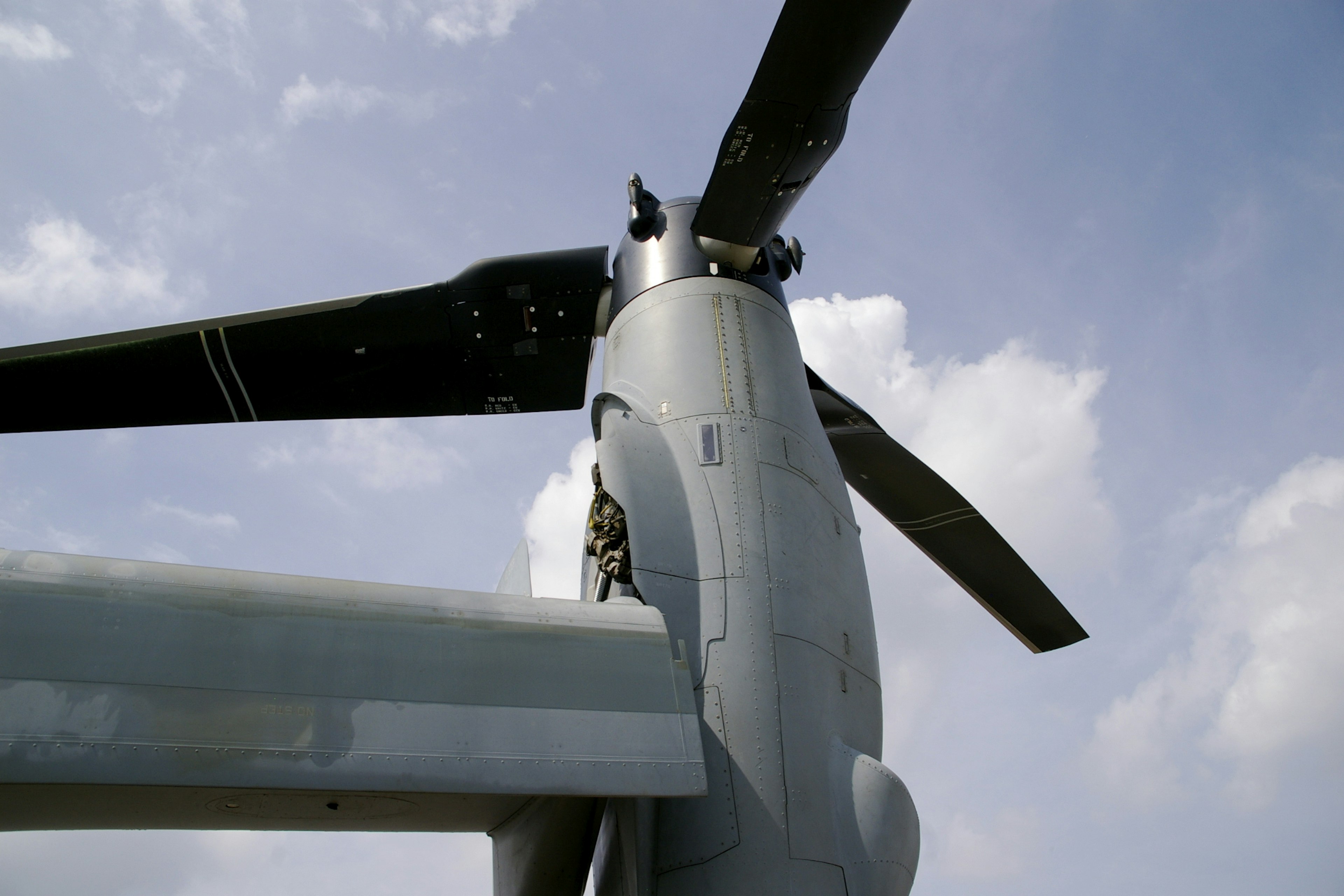 Close-up of a helicopter rotor and part of the fuselage against a blue sky