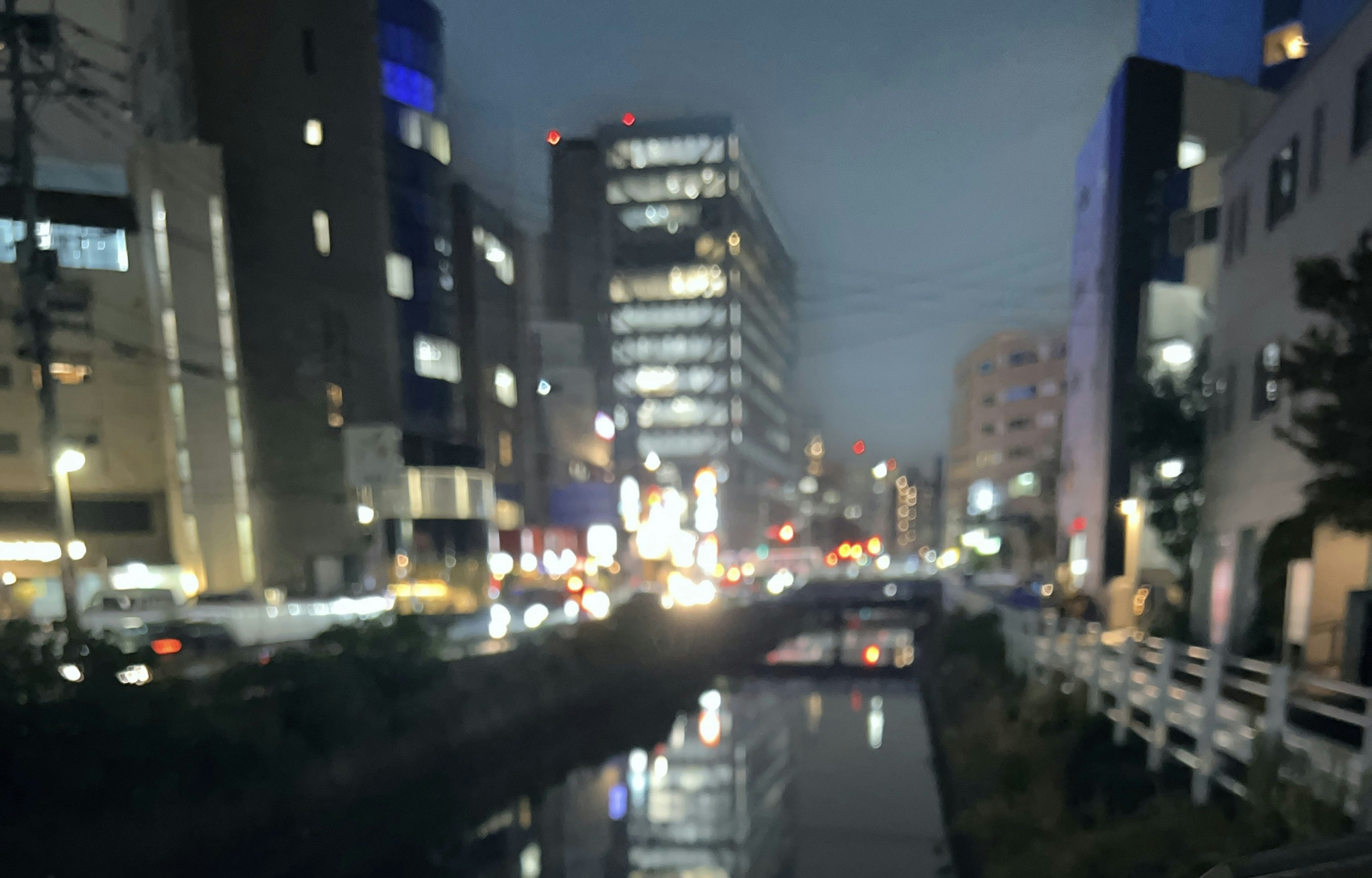 夜の都市風景に照らされたビルと川