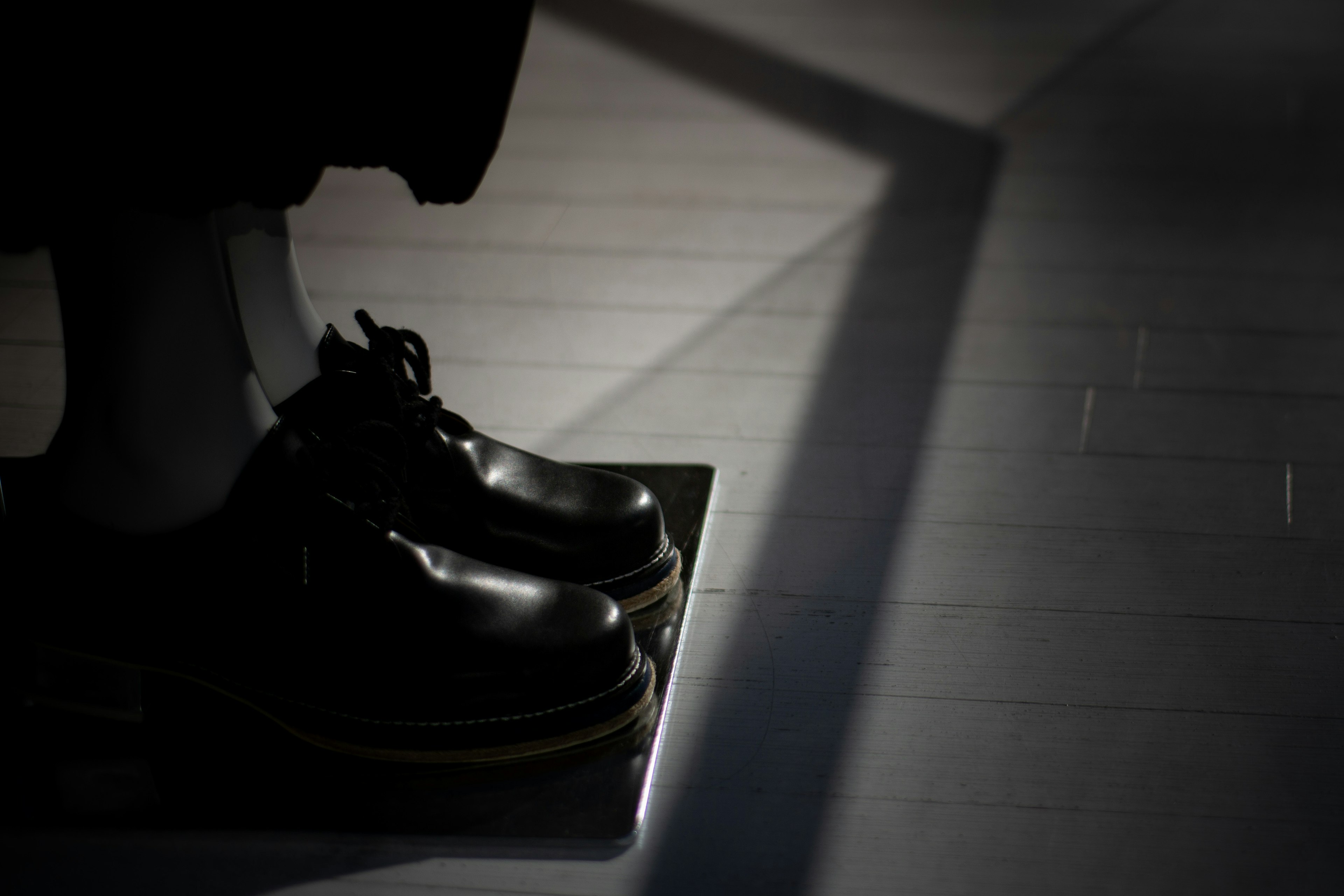 Silhouette of black shoes standing in light