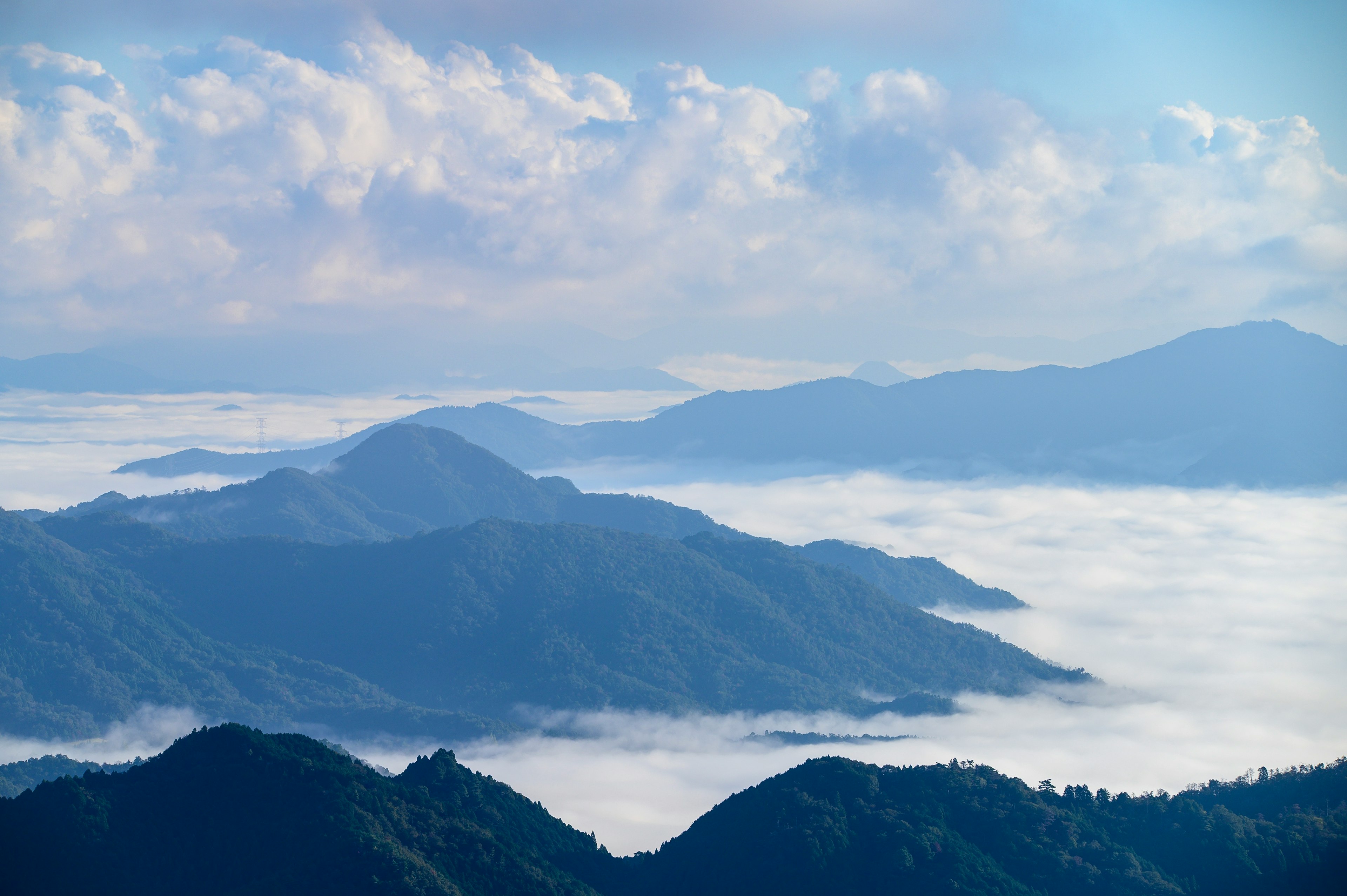 Panoramic view of mountains surrounded by blue sky and clouds