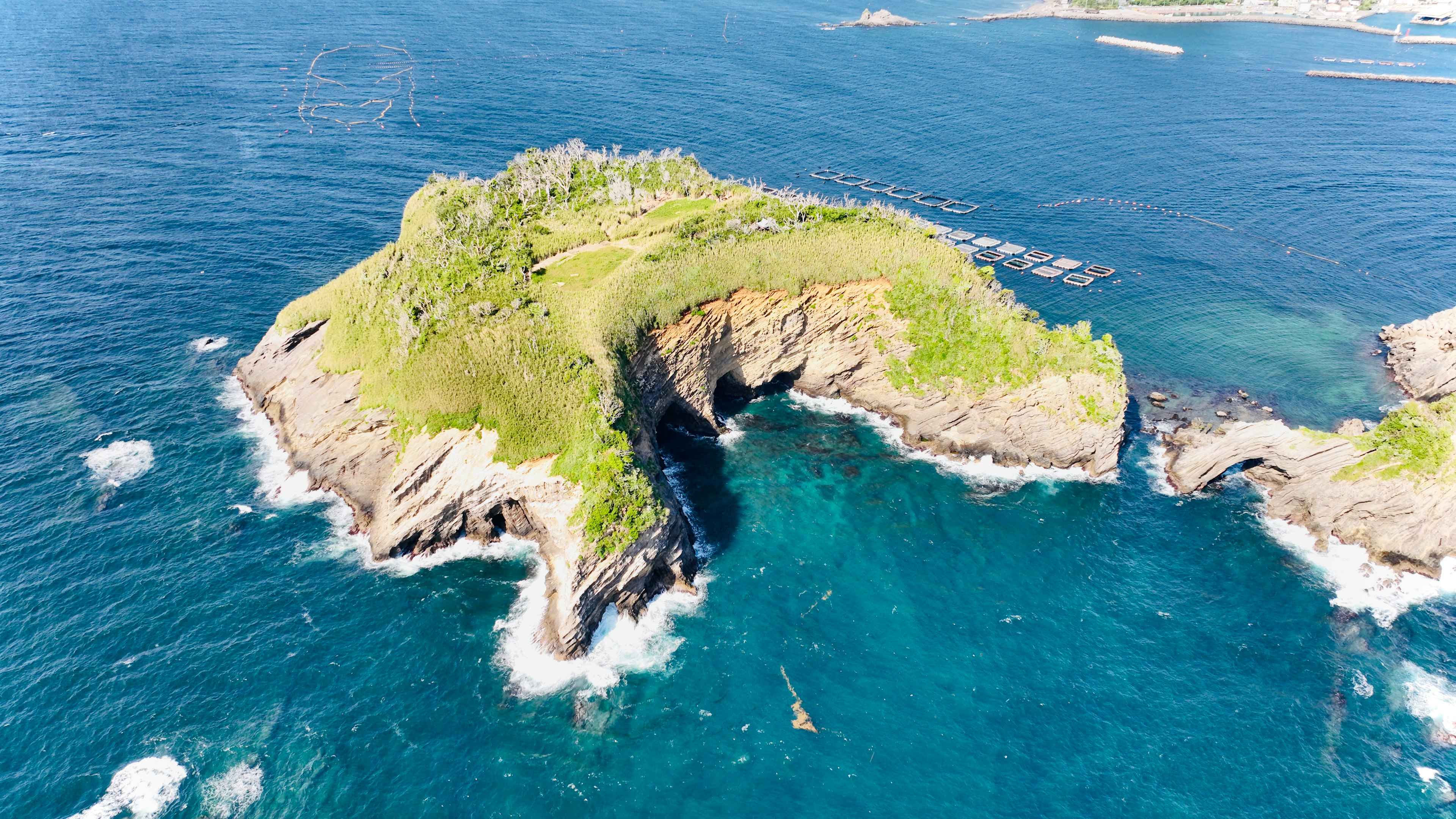 Aerial view of a lush green island surrounded by blue ocean