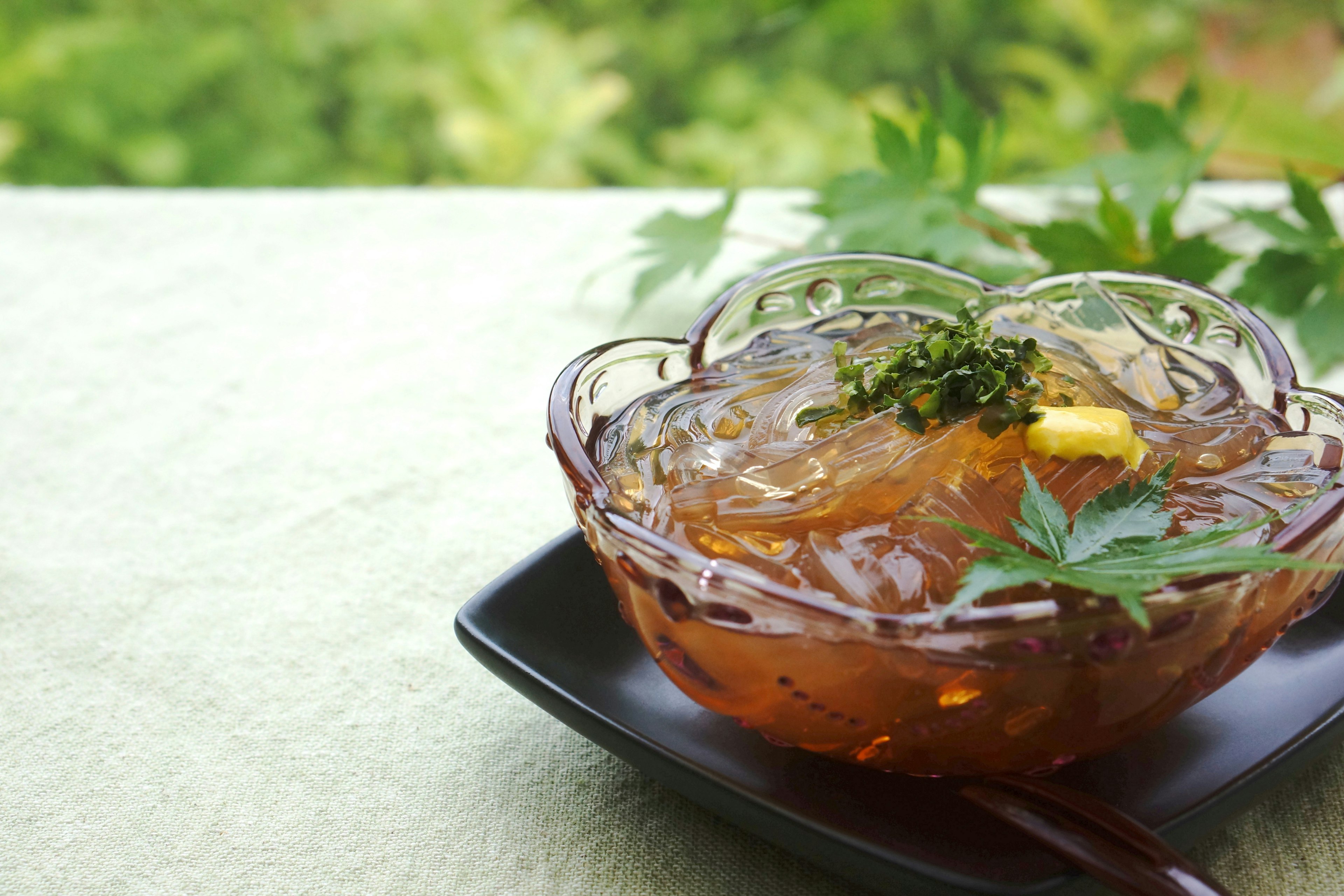 A transparent jelly dessert topped with lemon and herbs