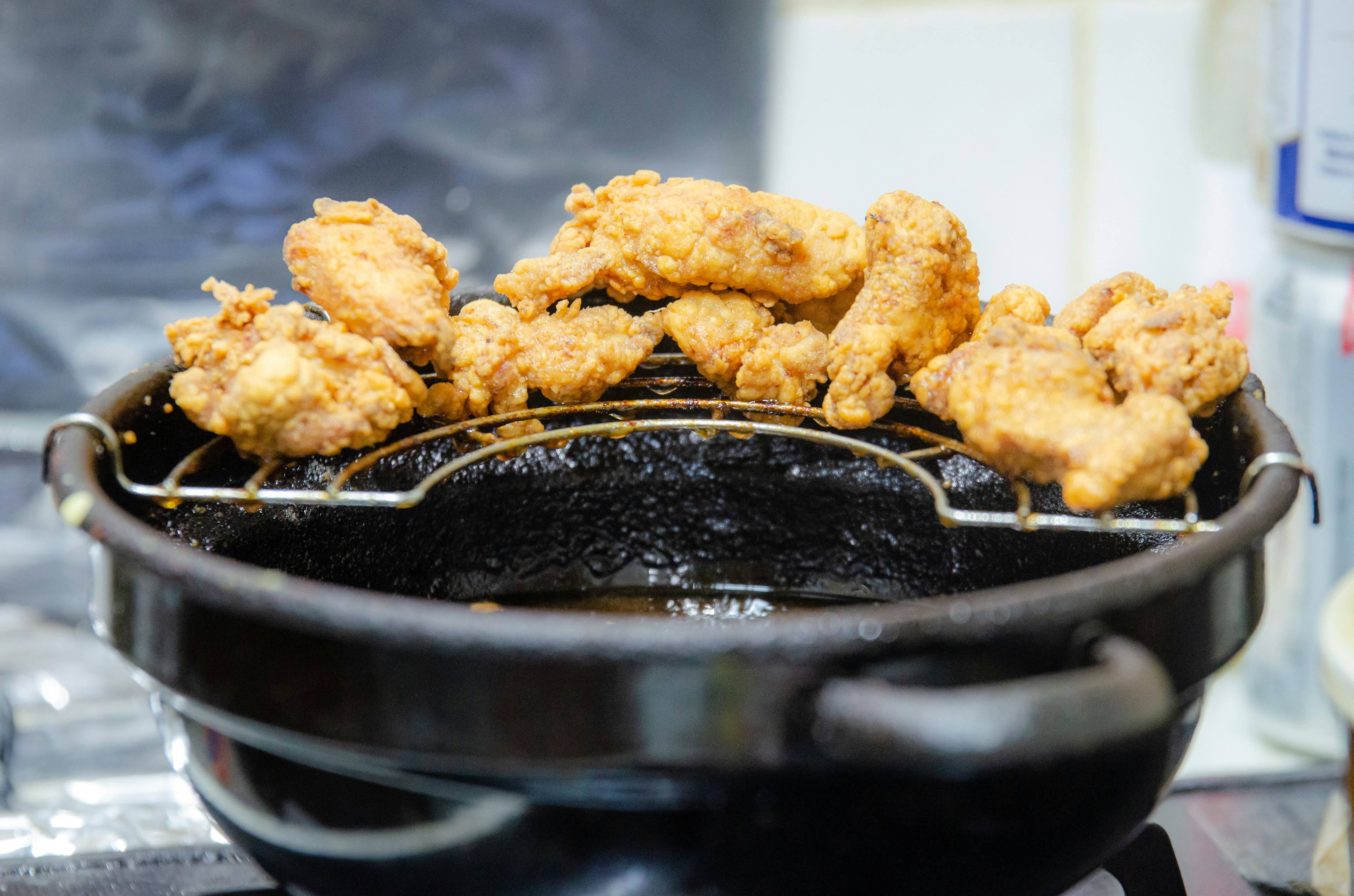 揚げた鶏肉が黒い鍋の上に載っている