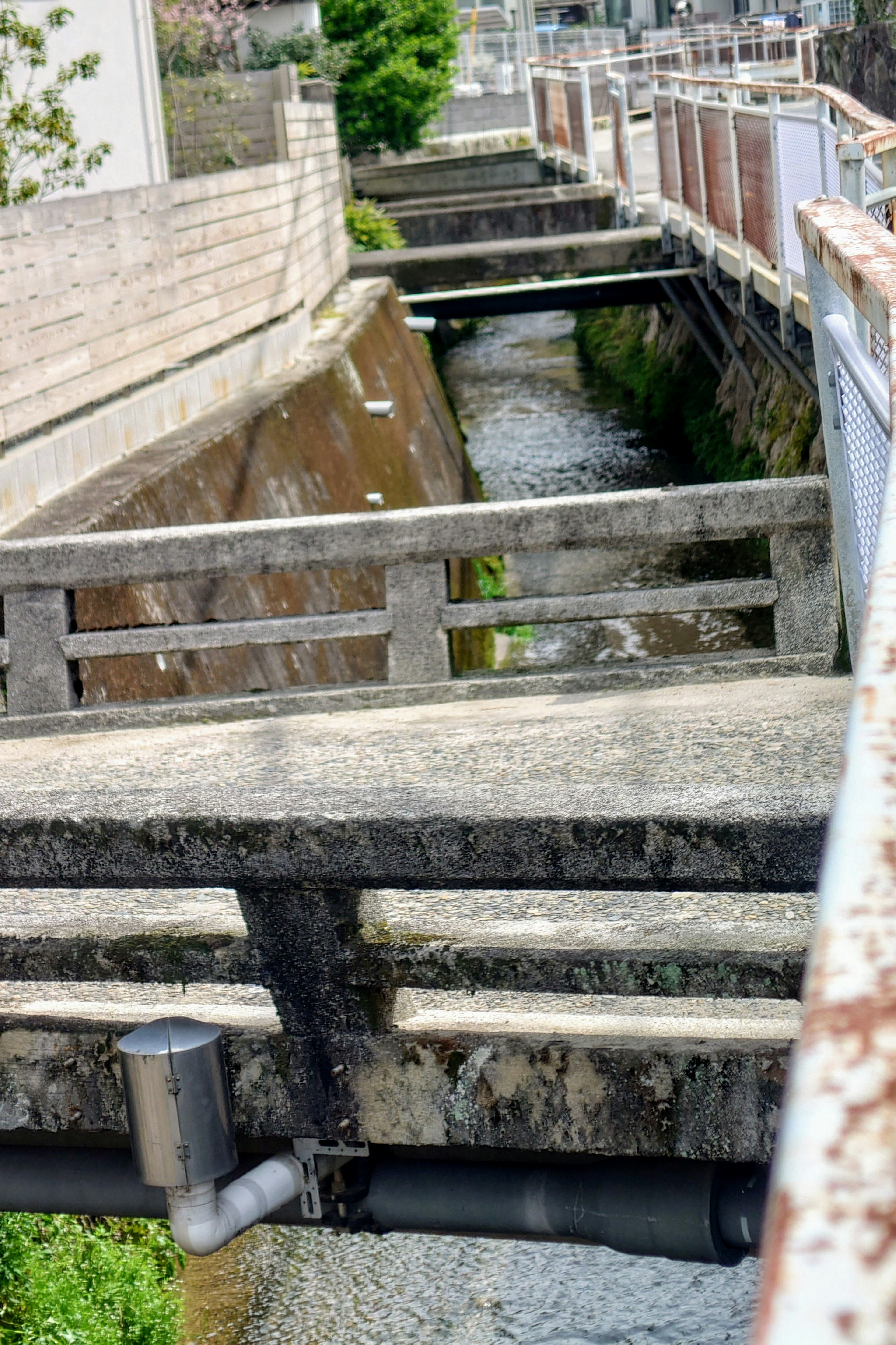 Narrow waterway with concrete bridges in an urban setting