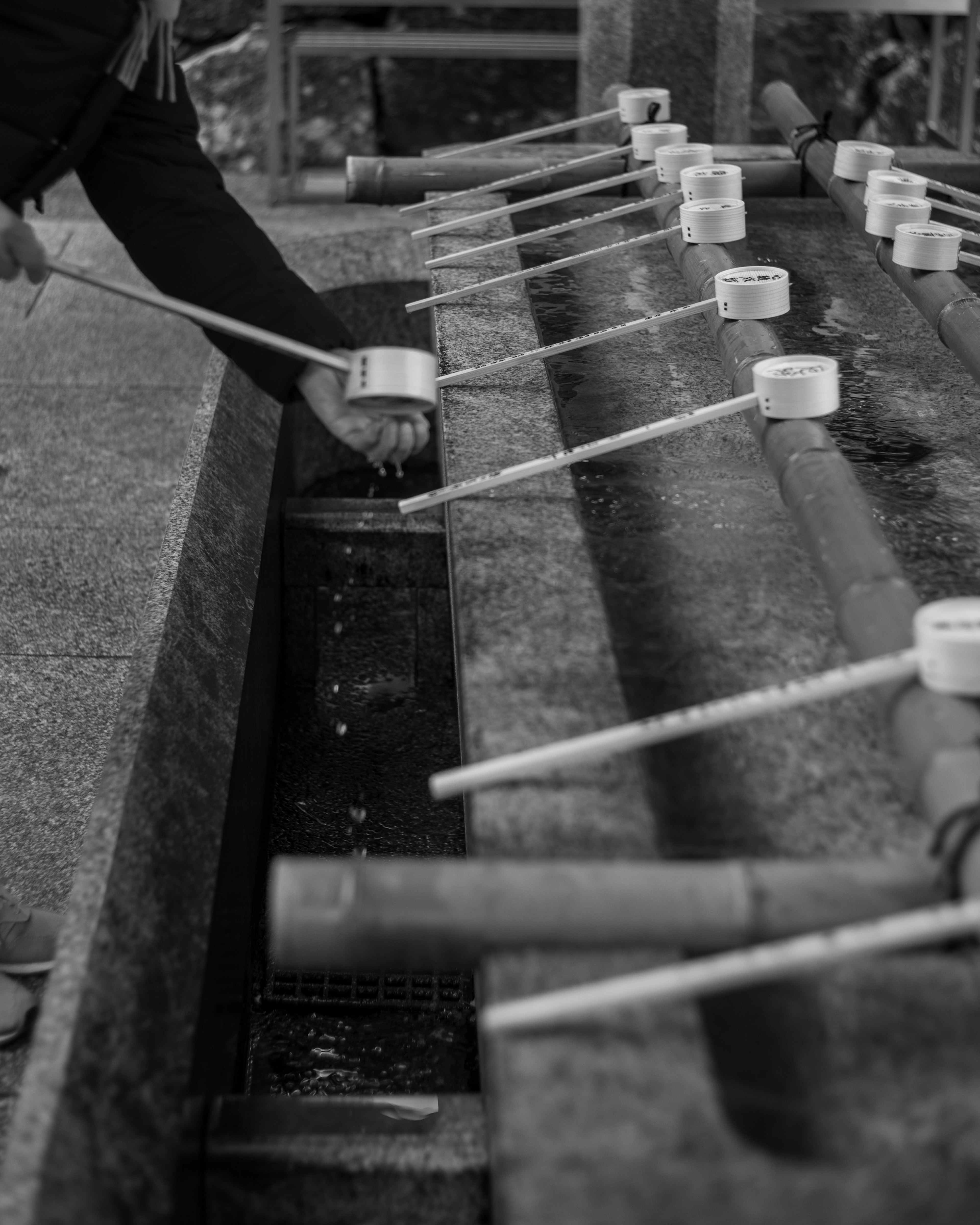 Personne utilisant une louche pour puiser de l'eau à une fontaine de purification