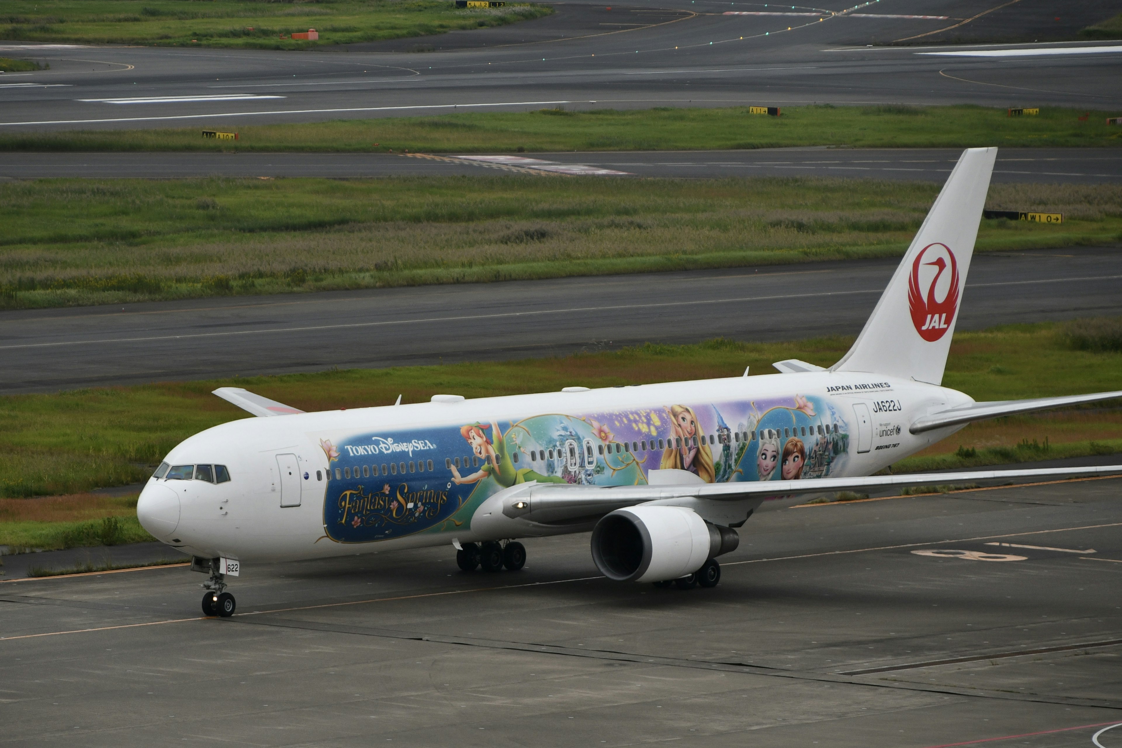 เครื่องบิน Japan Airlines ที่มีสีพิเศษกำลังวิ่งอยู่บนทางวิ่ง