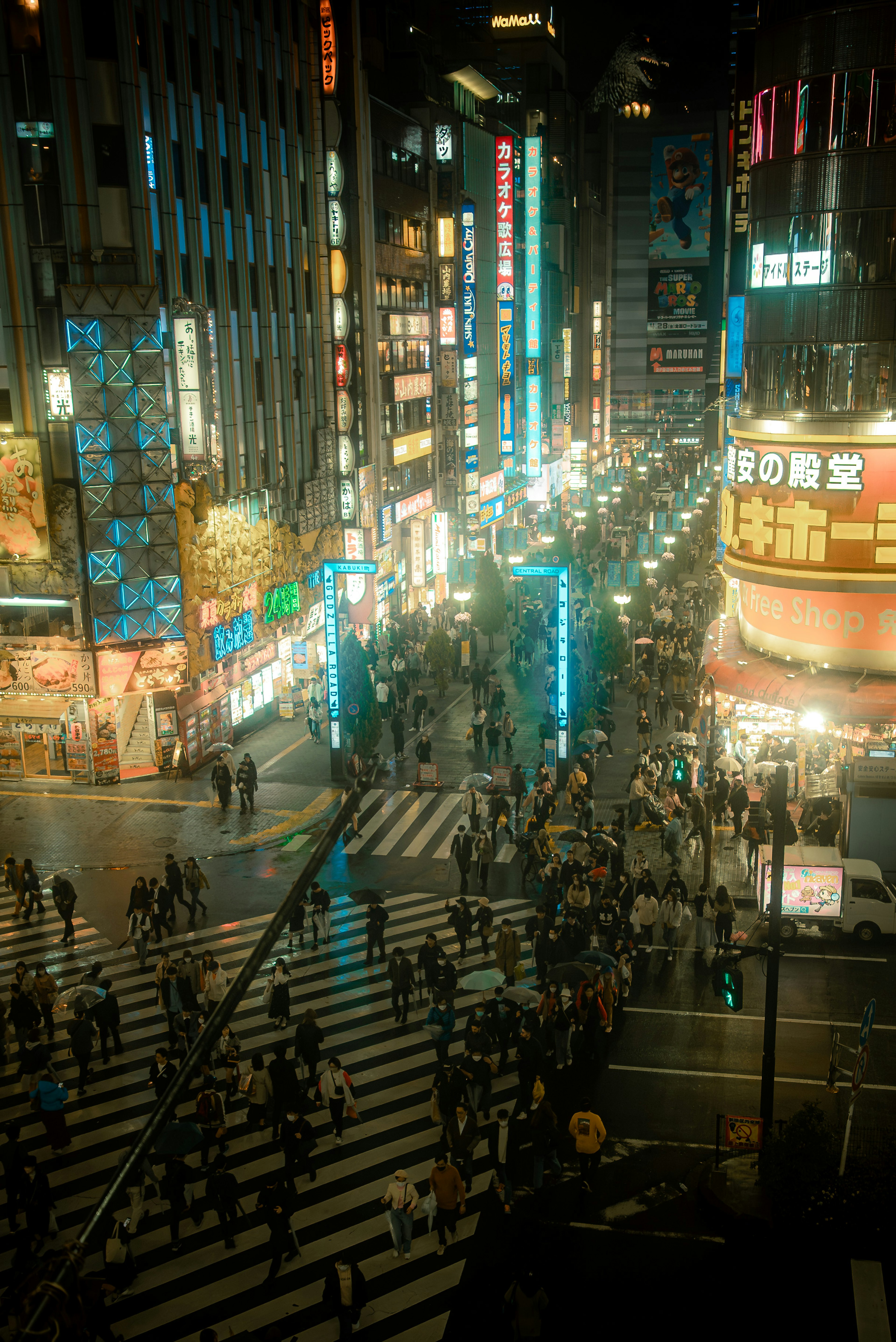 東京繁華街道的夜景 人潮穿越十字路口 發光的霓虹燈招牌