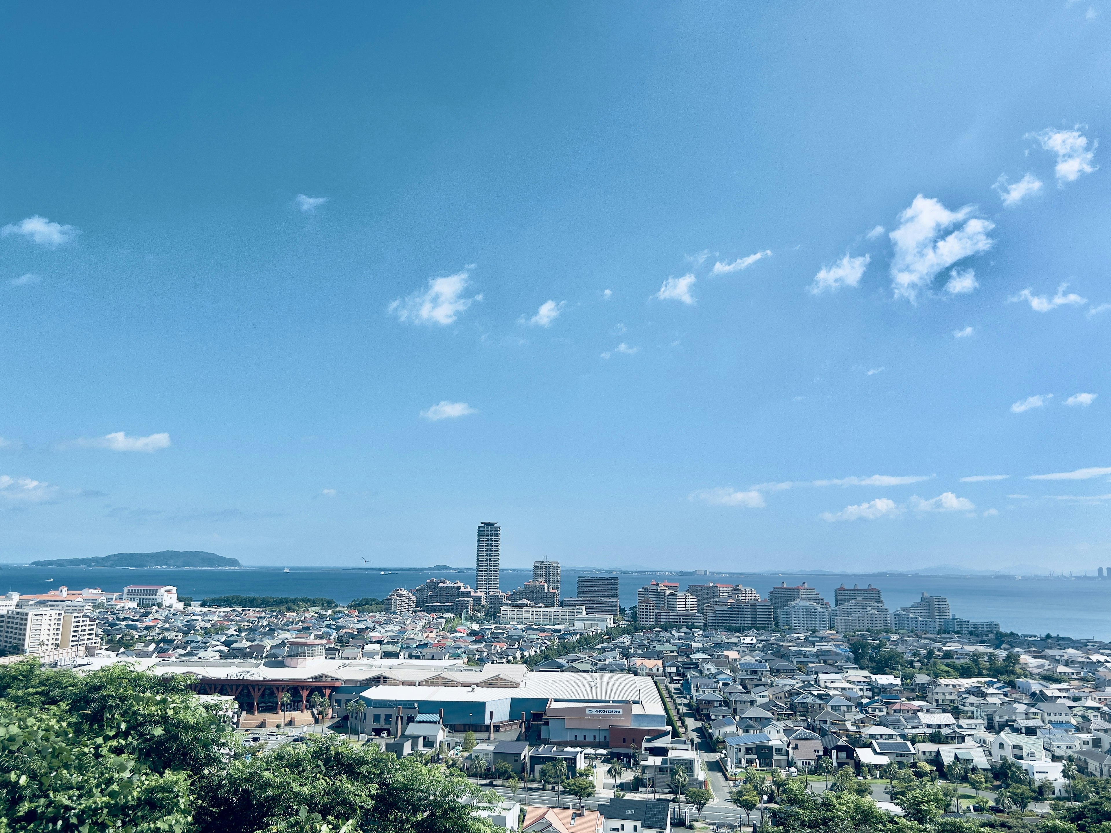 Paysage urbain avec un ciel bleu clair et des nuages présentant la mer et les montagnes