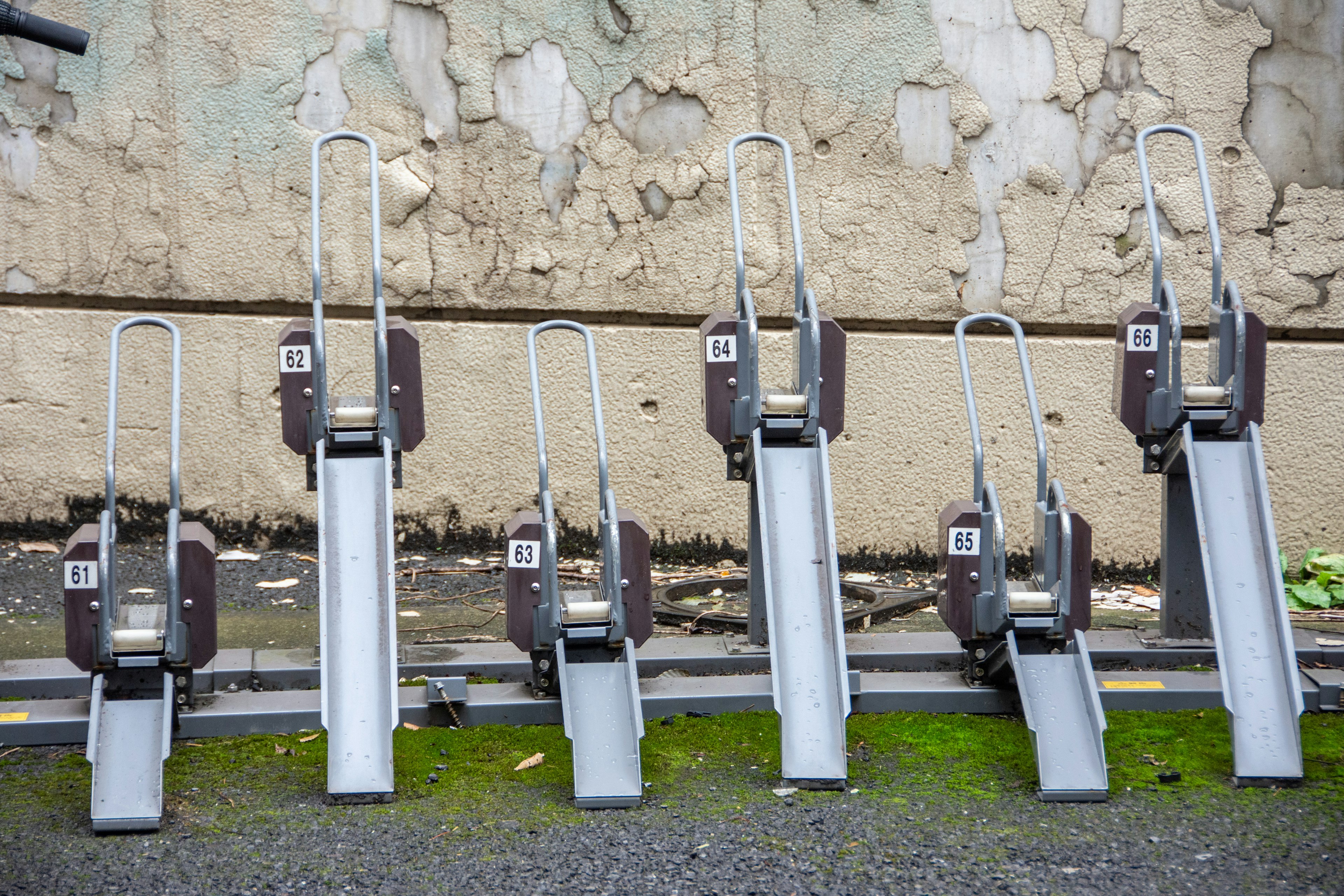 Row of vintage bicycle rental stands against a weathered wall