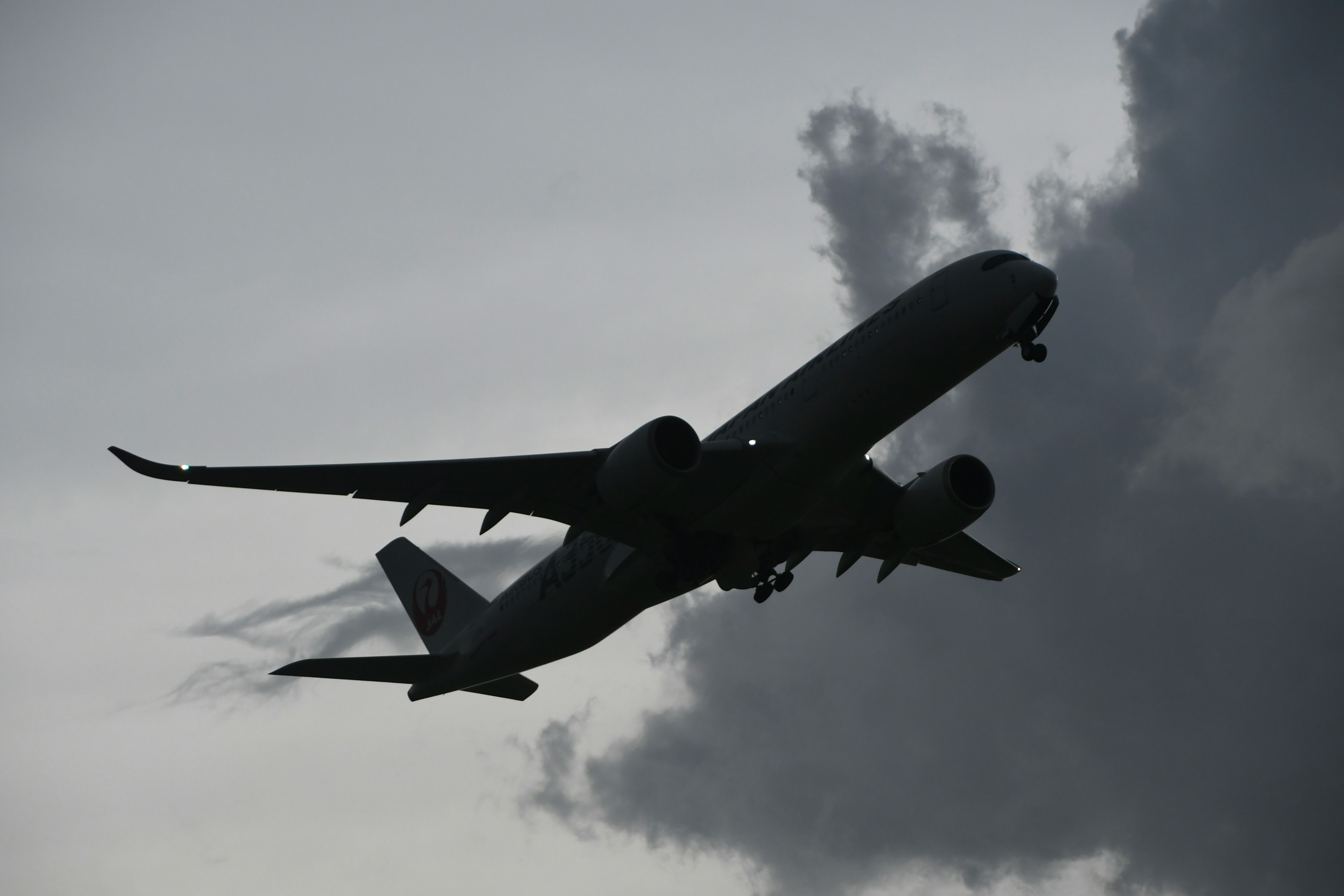 Silhouette di un aereo che decolla tra le nuvole