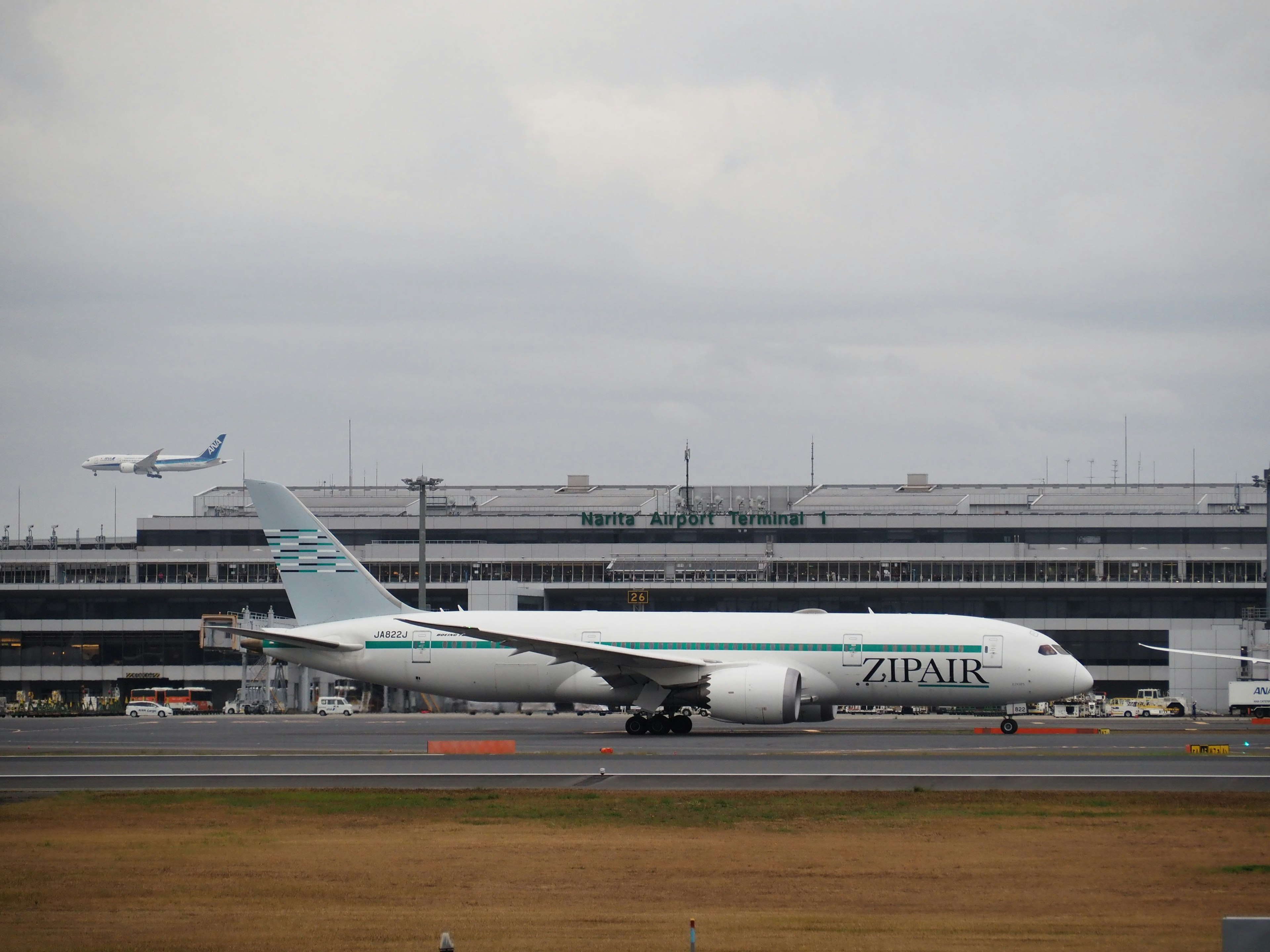 Finnair aircraft parked at the airport with another plane taking off