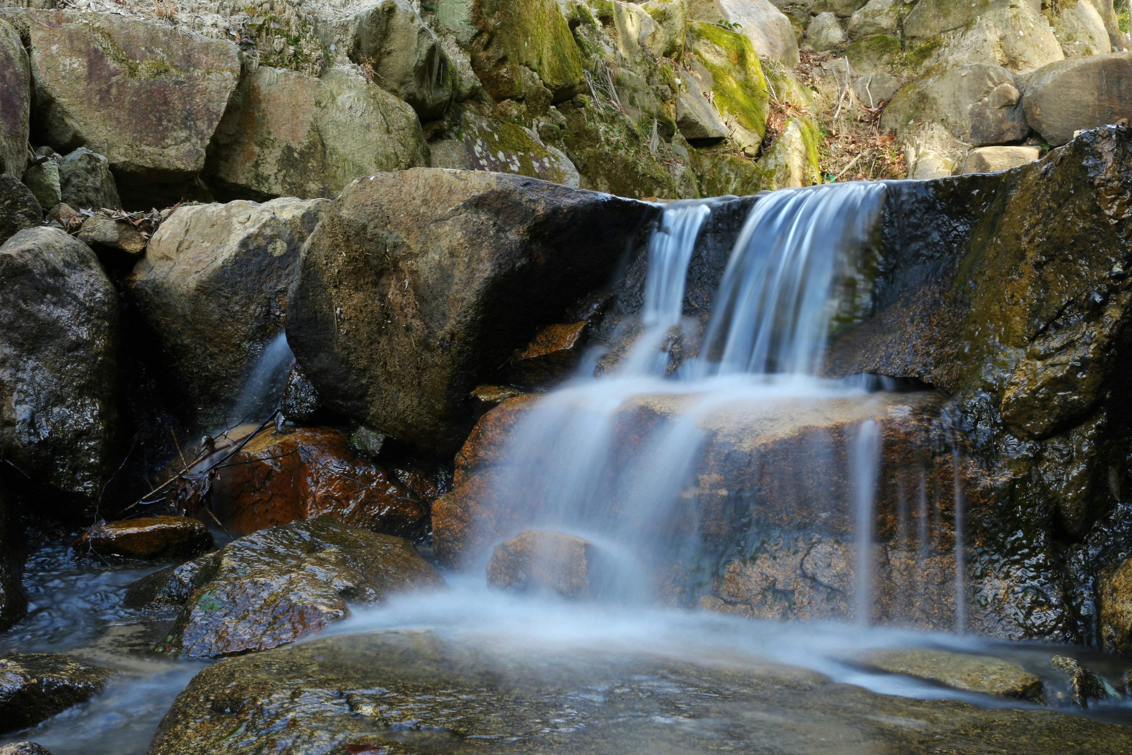 Une belle scène d'une petite cascade coulant entre les rochers