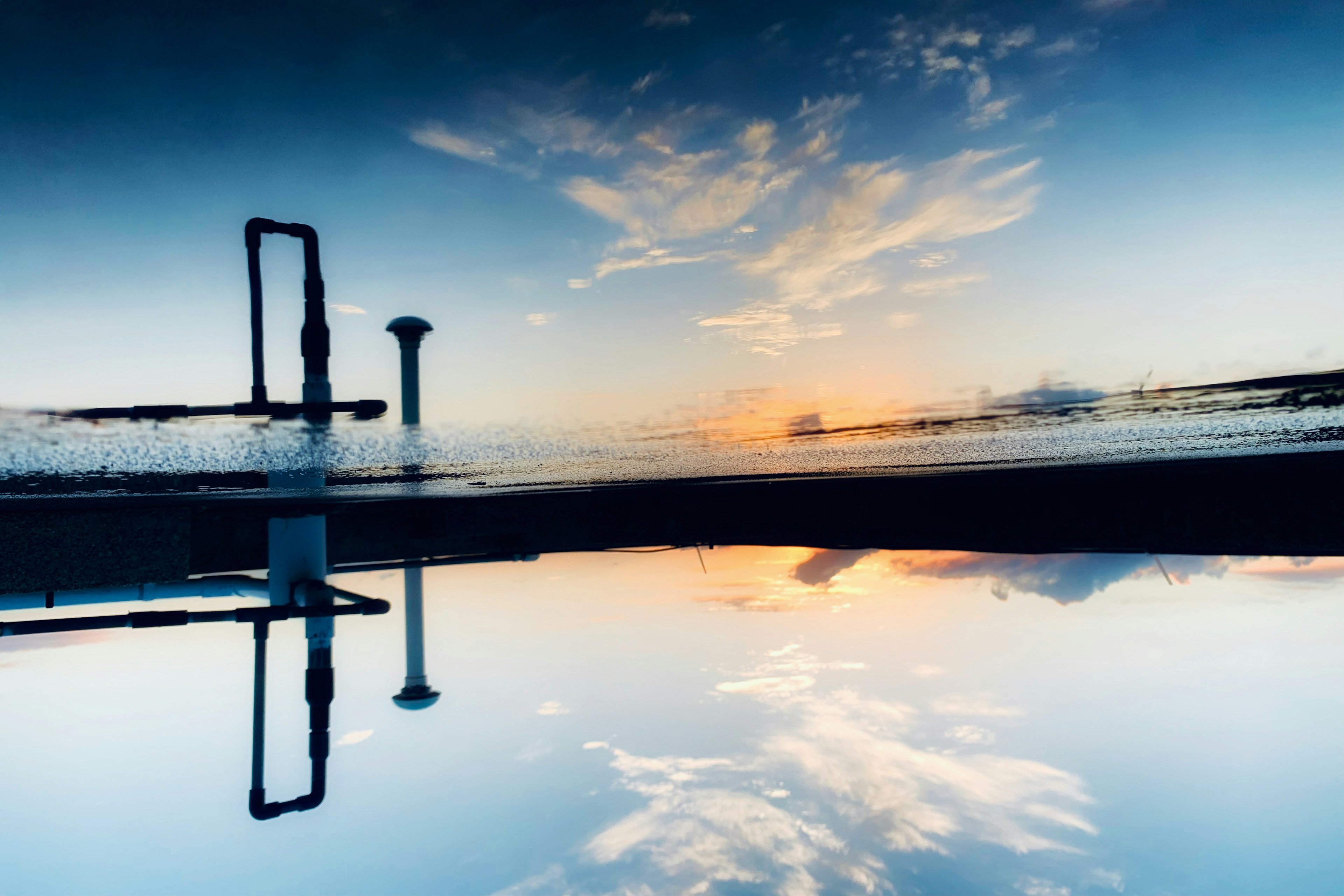 Réflexion du ciel matinal et des nuages sur la surface de l'eau Silhouette des structures créant une belle scène