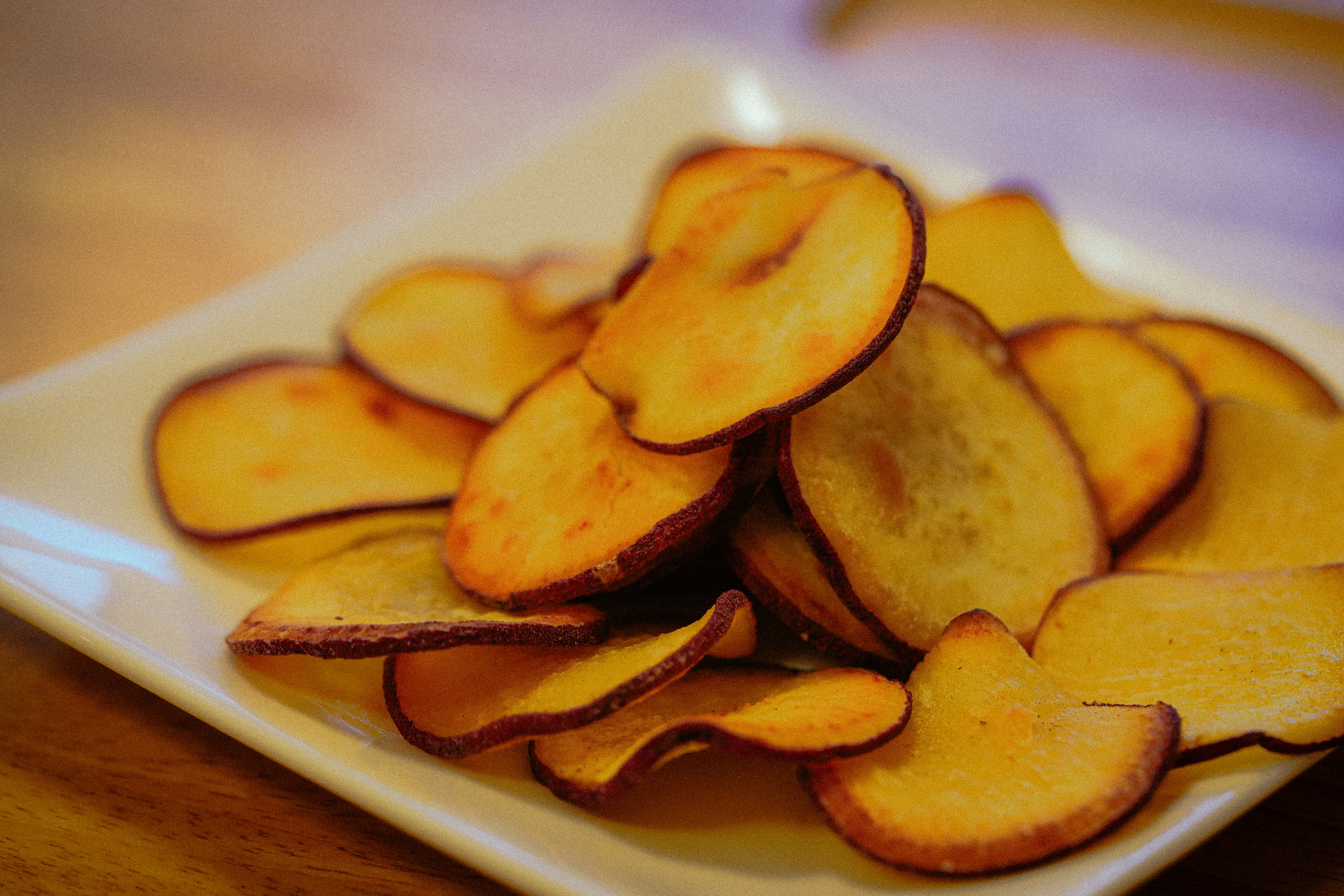 A pile of sweet potato chips on a plate