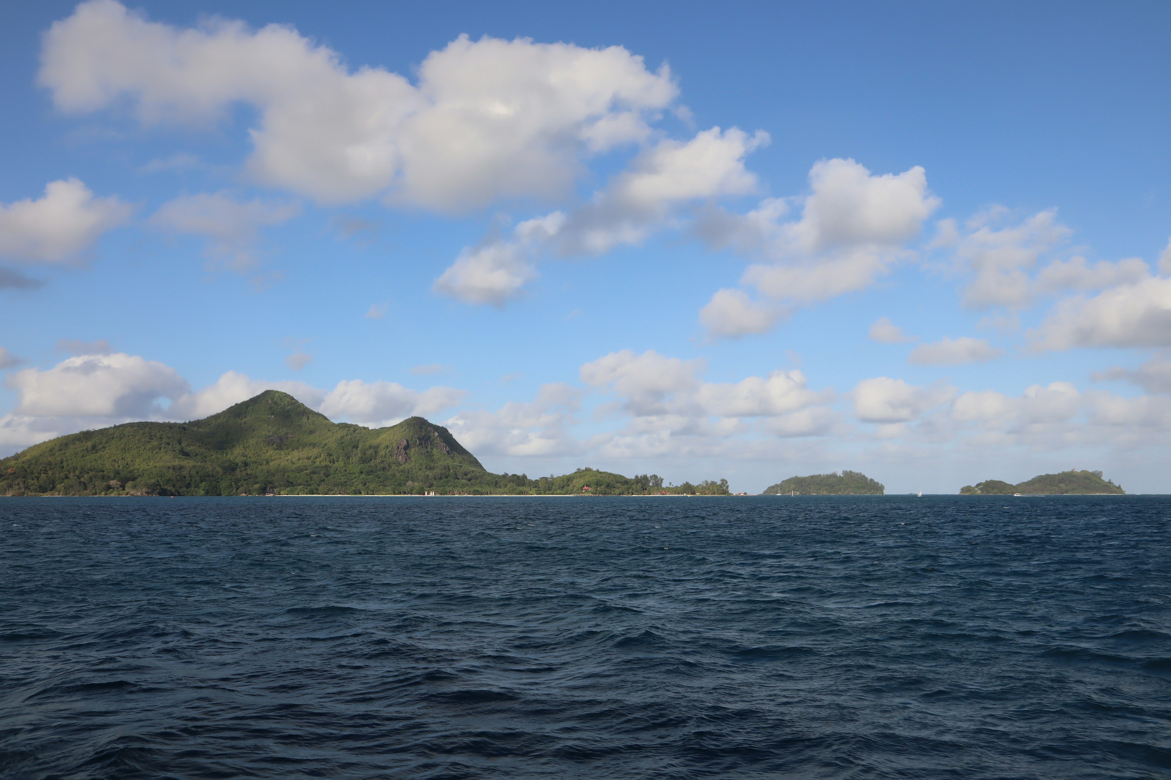 ภูมิทัศน์ของทะเลและเกาะ ใต้ท้องฟ้าสีฟ้าและเมฆขาว