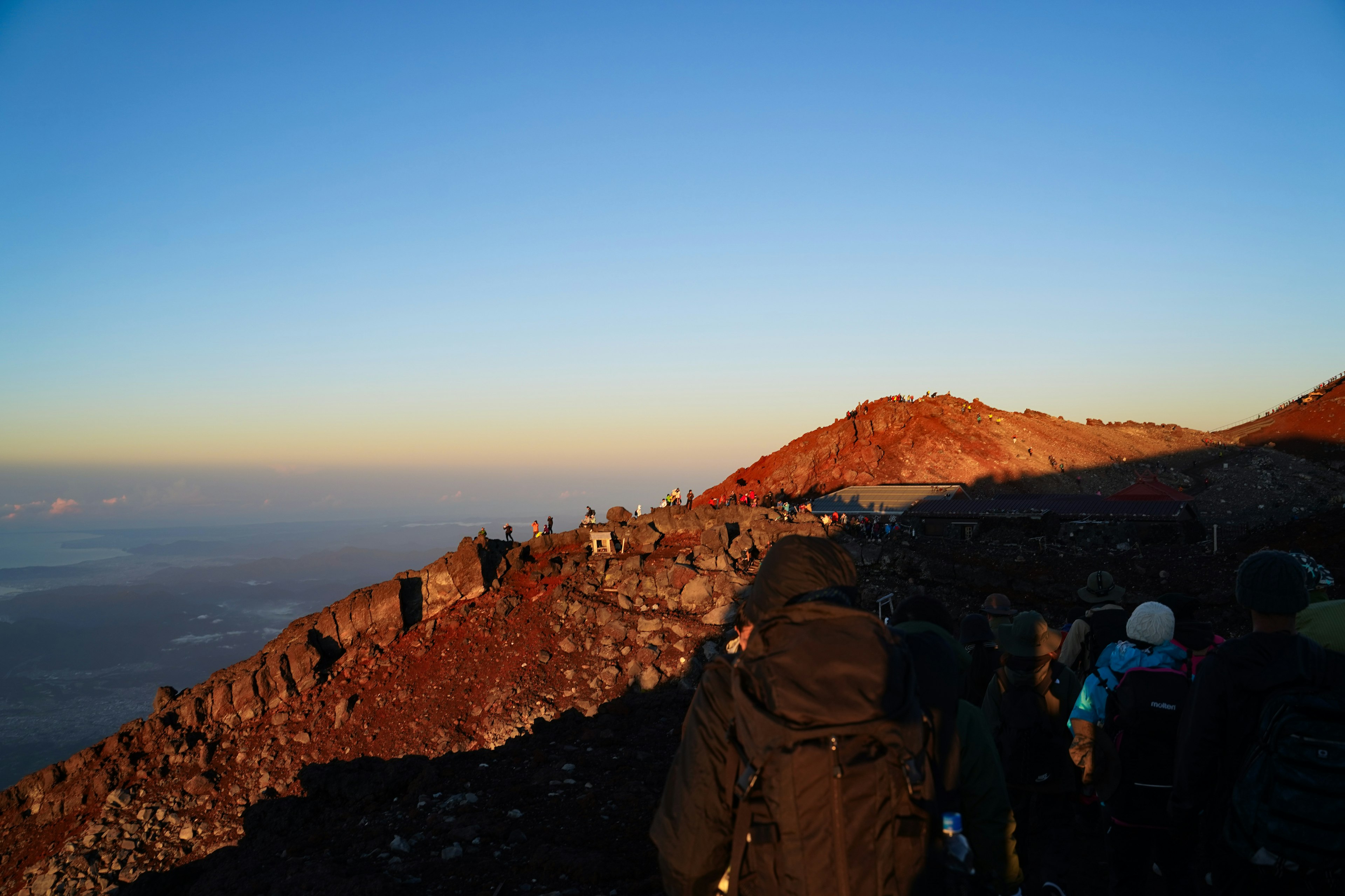 Escursionisti che salgono una montagna con cielo blu chiaro