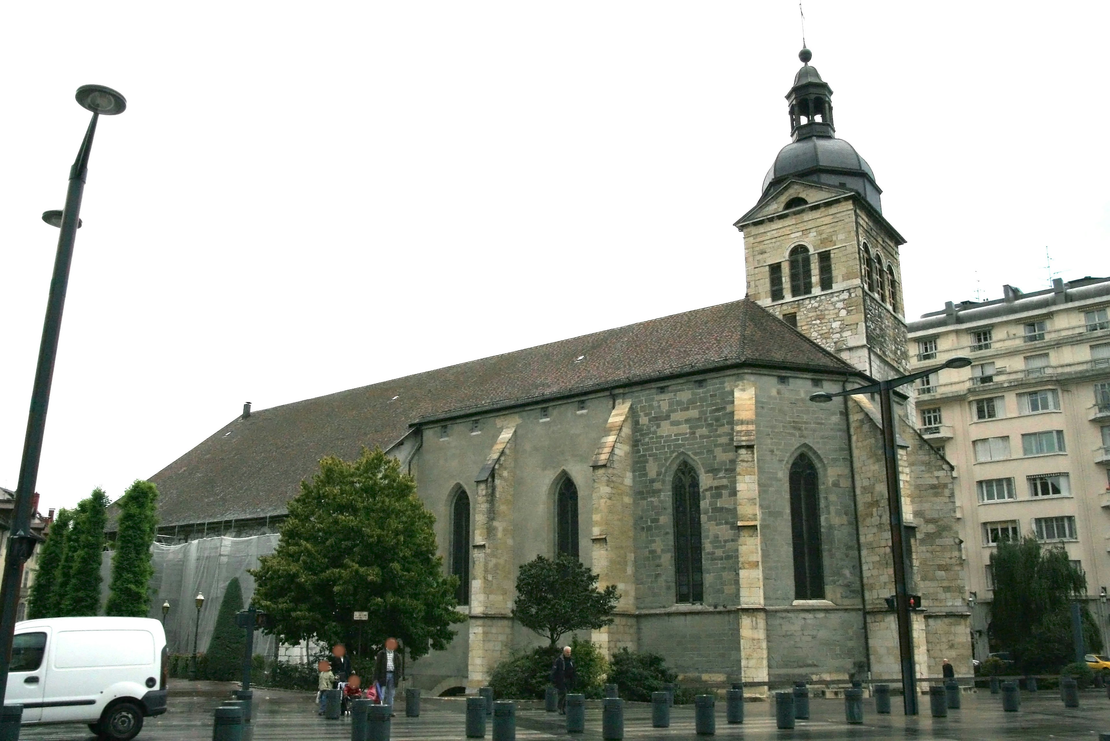 Graue Steinkirche mit grünen Bäumen in der Umgebung