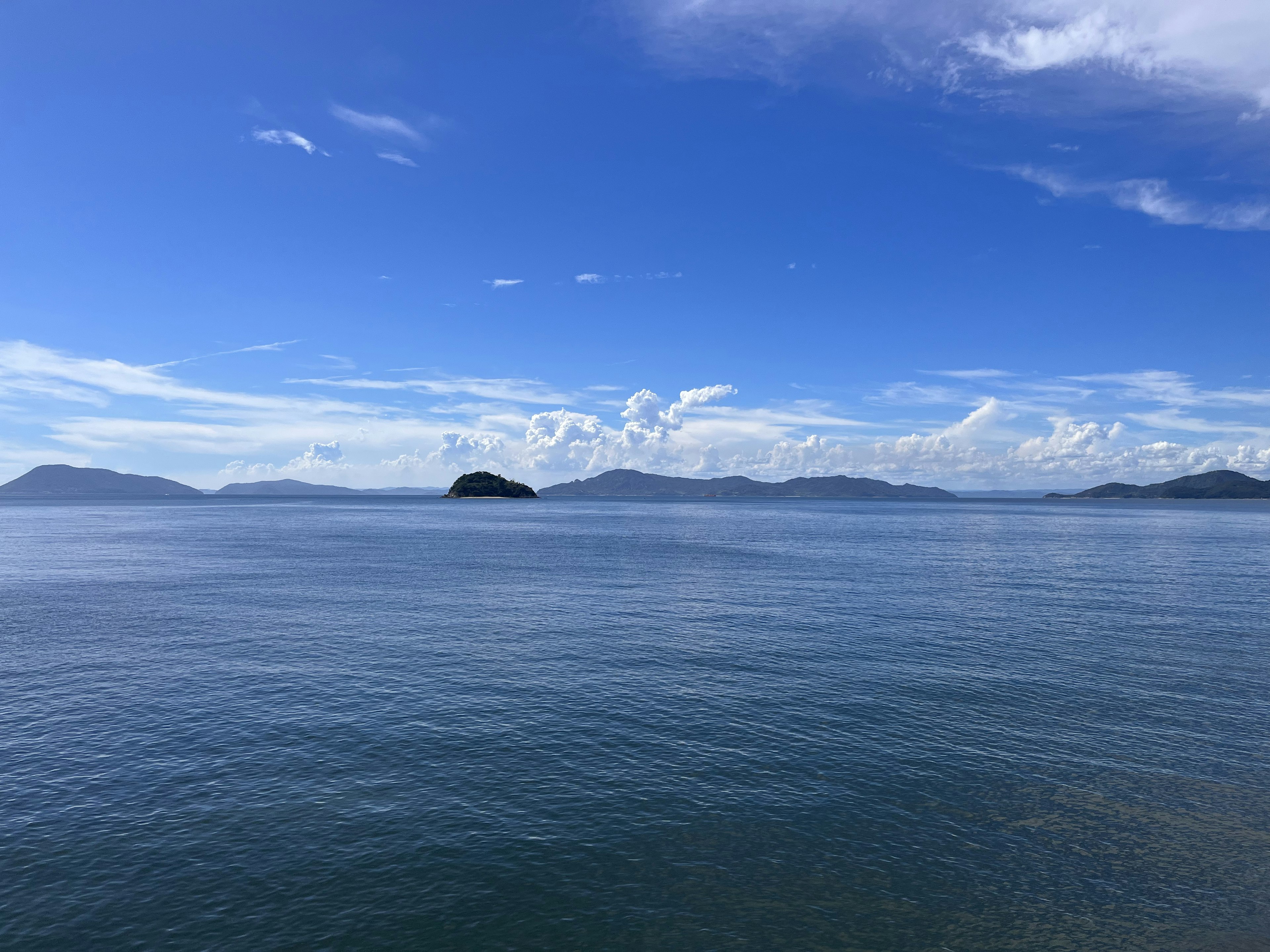 青い空と穏やかな海が広がる風景 遠くに小さな島々が見える