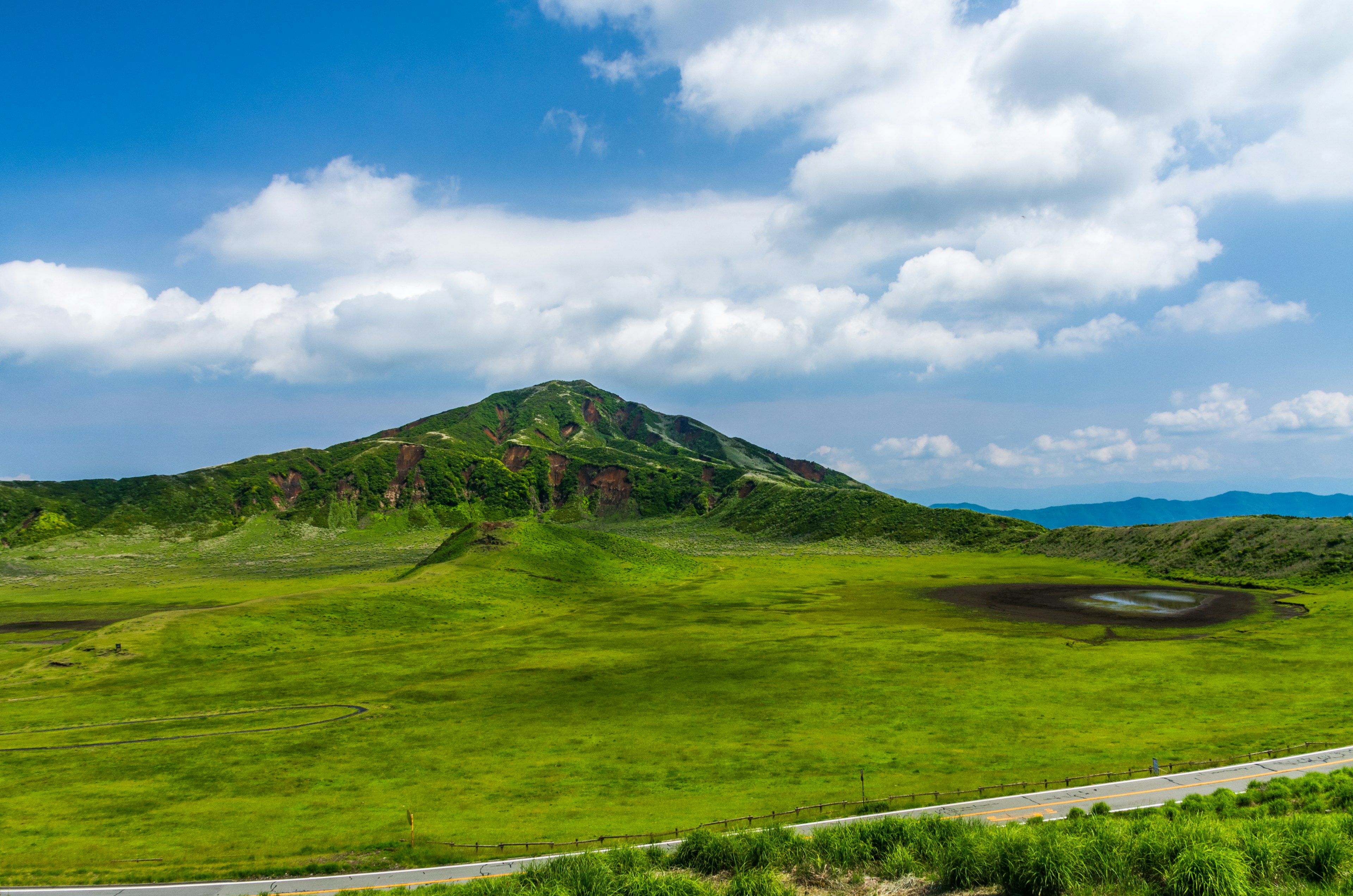 绿色田野和蓝天下的山脉风景