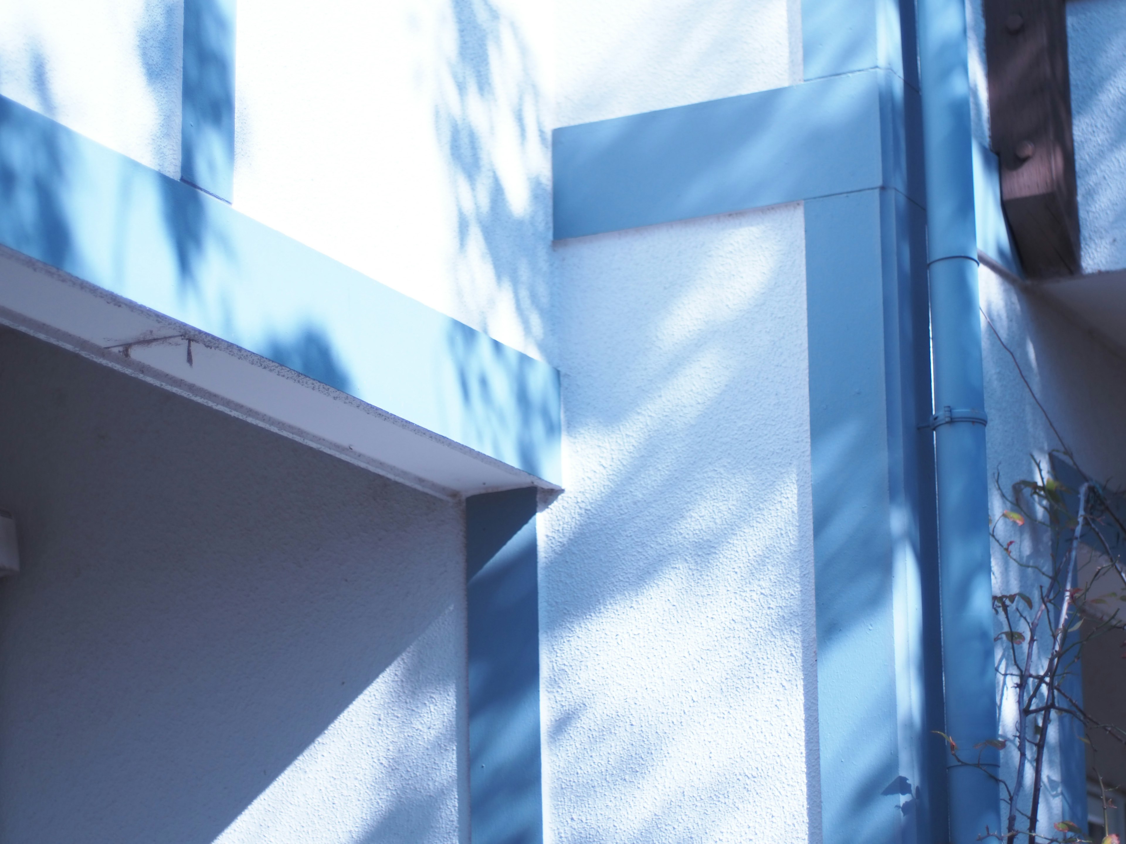 Parte de un edificio con paredes azules y sombras